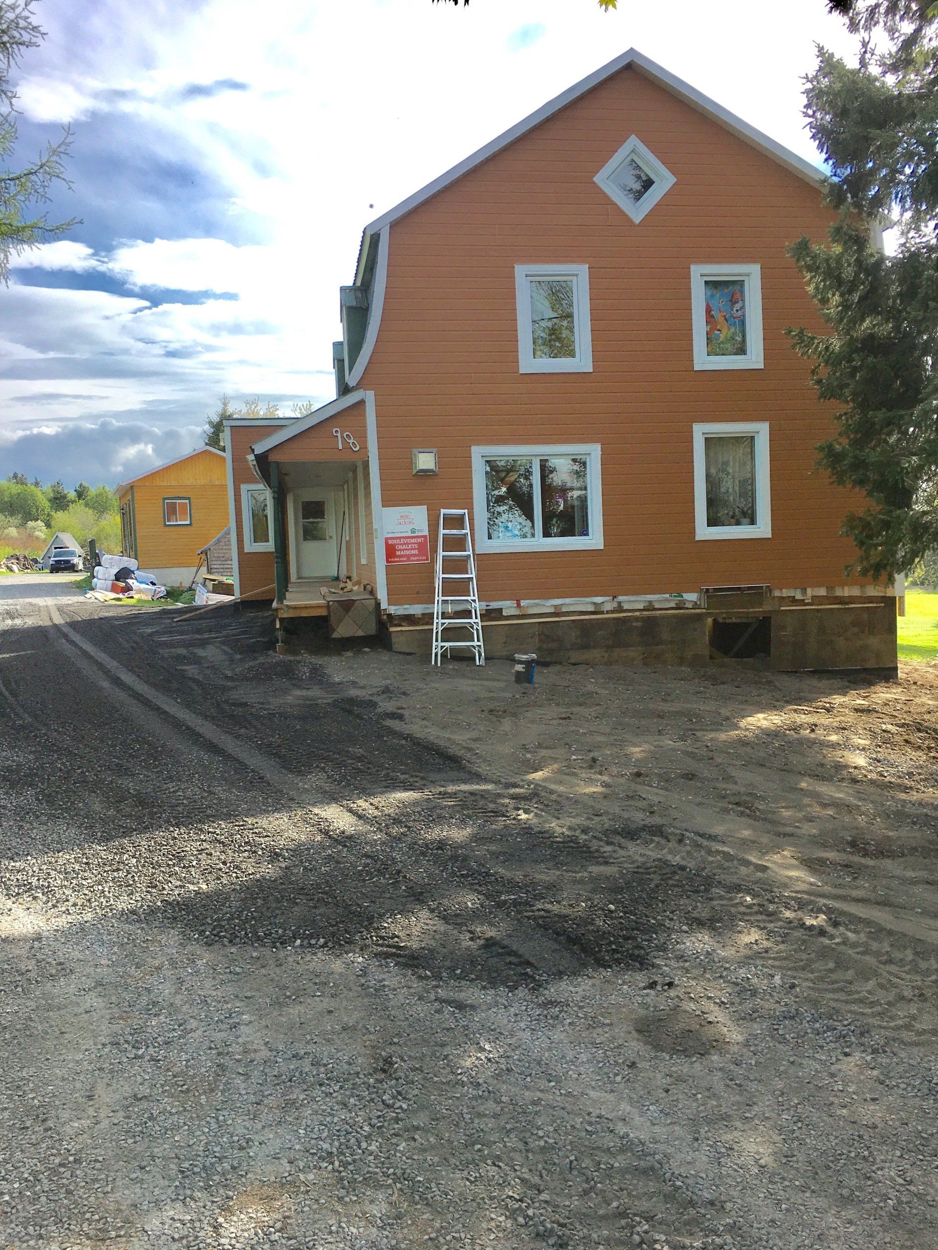 Une grande maison orange avec une échelle devant