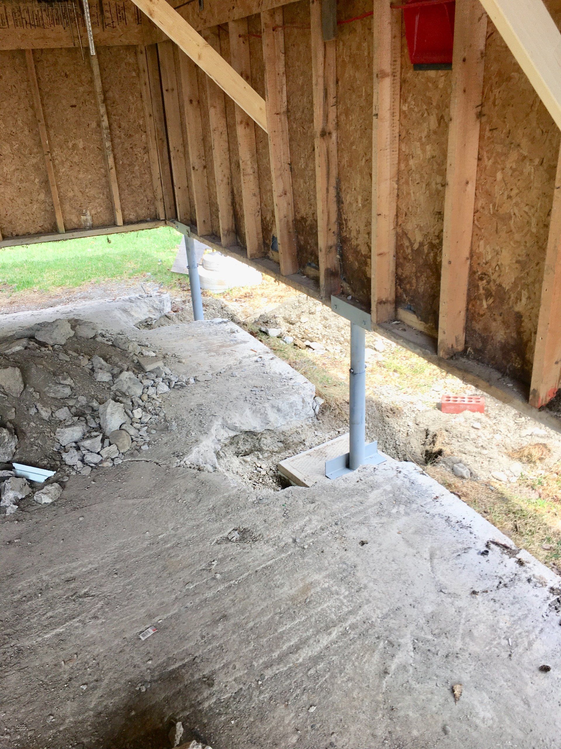 Un bâtiment en construction avec un sol en béton et un mur en bois.