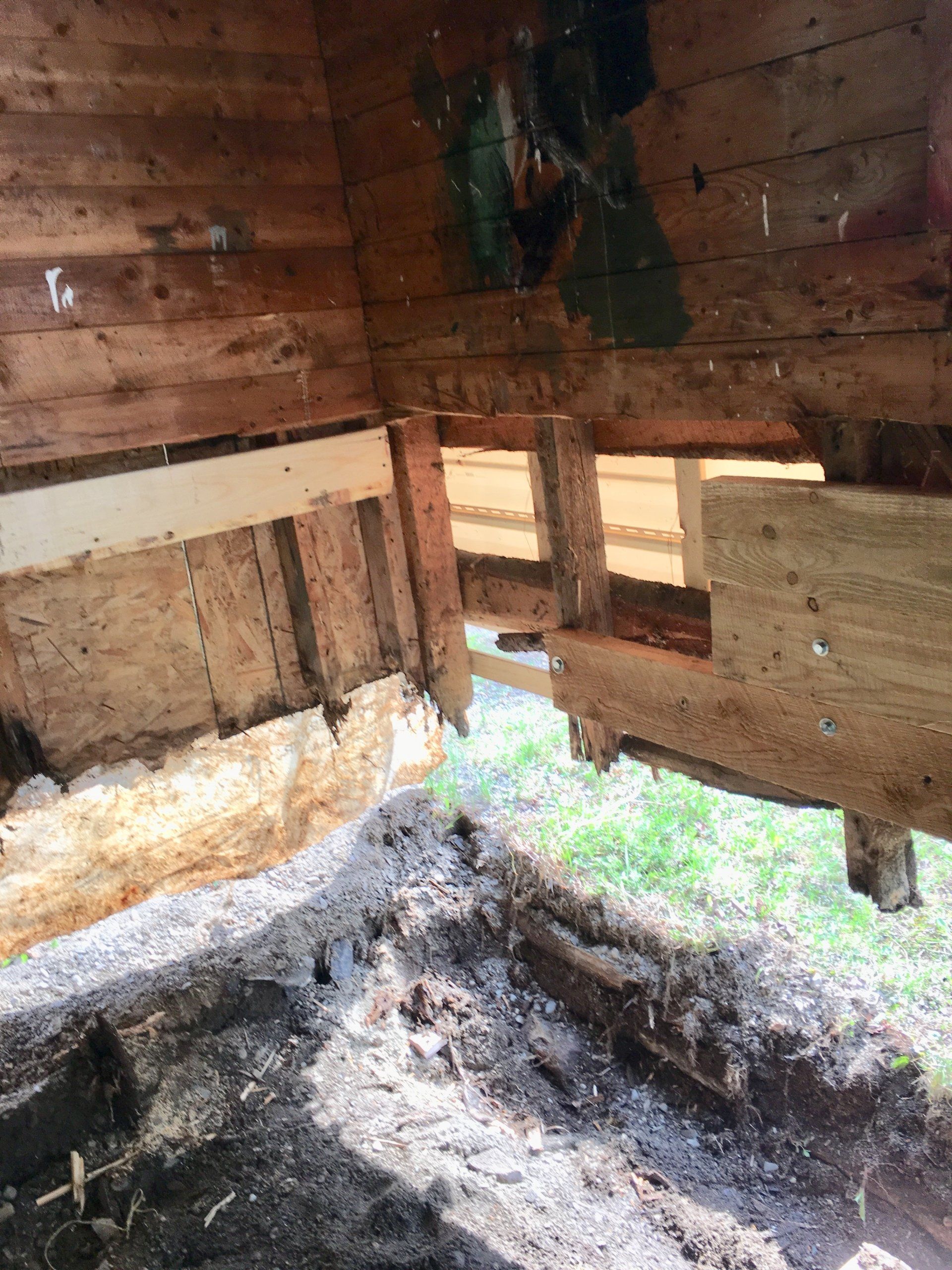 L'intérieur d'un bâtiment en bois avec beaucoup de bois posé sur le sol.
