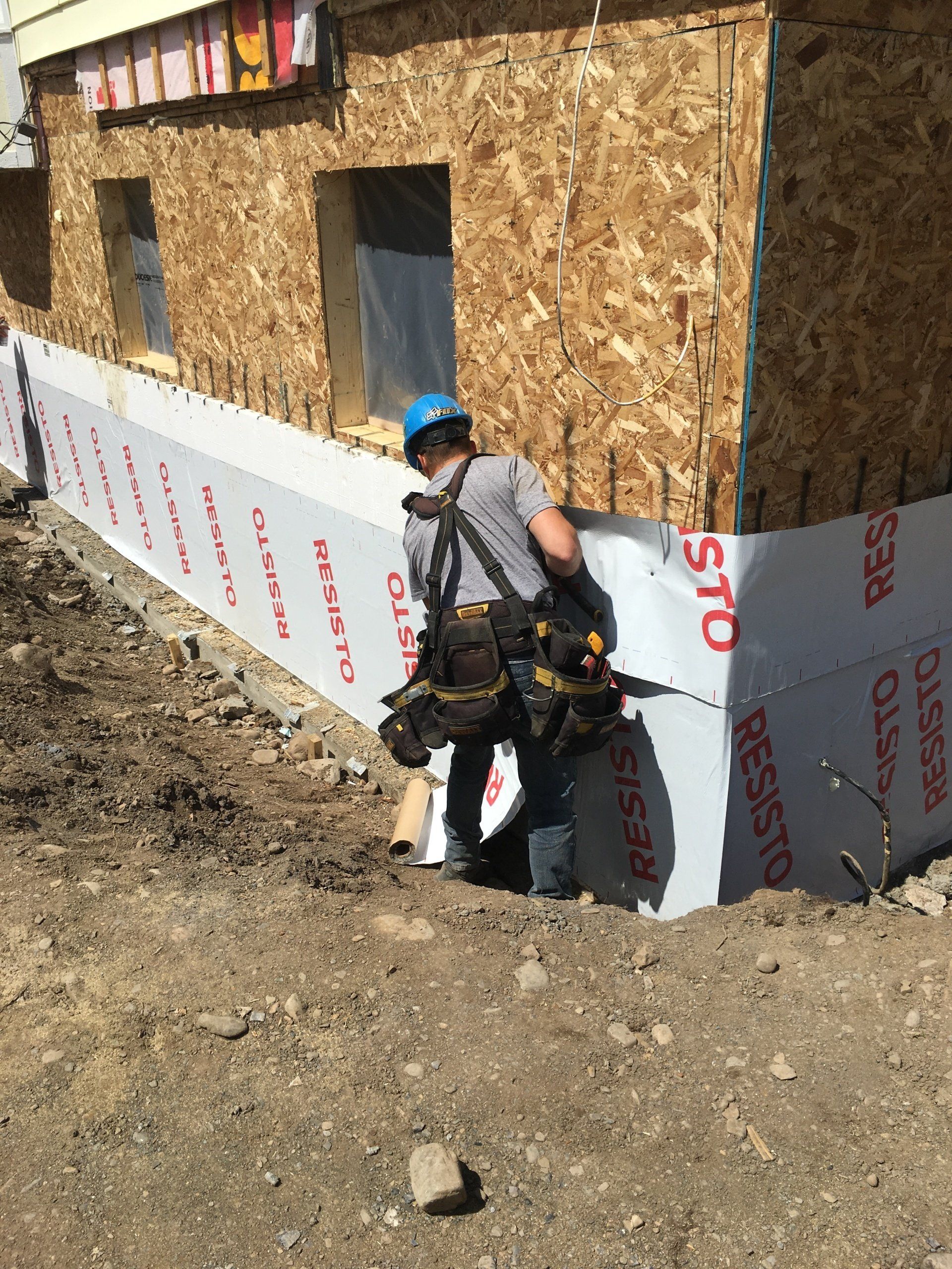 Un homme se tient devant un bâtiment en construction