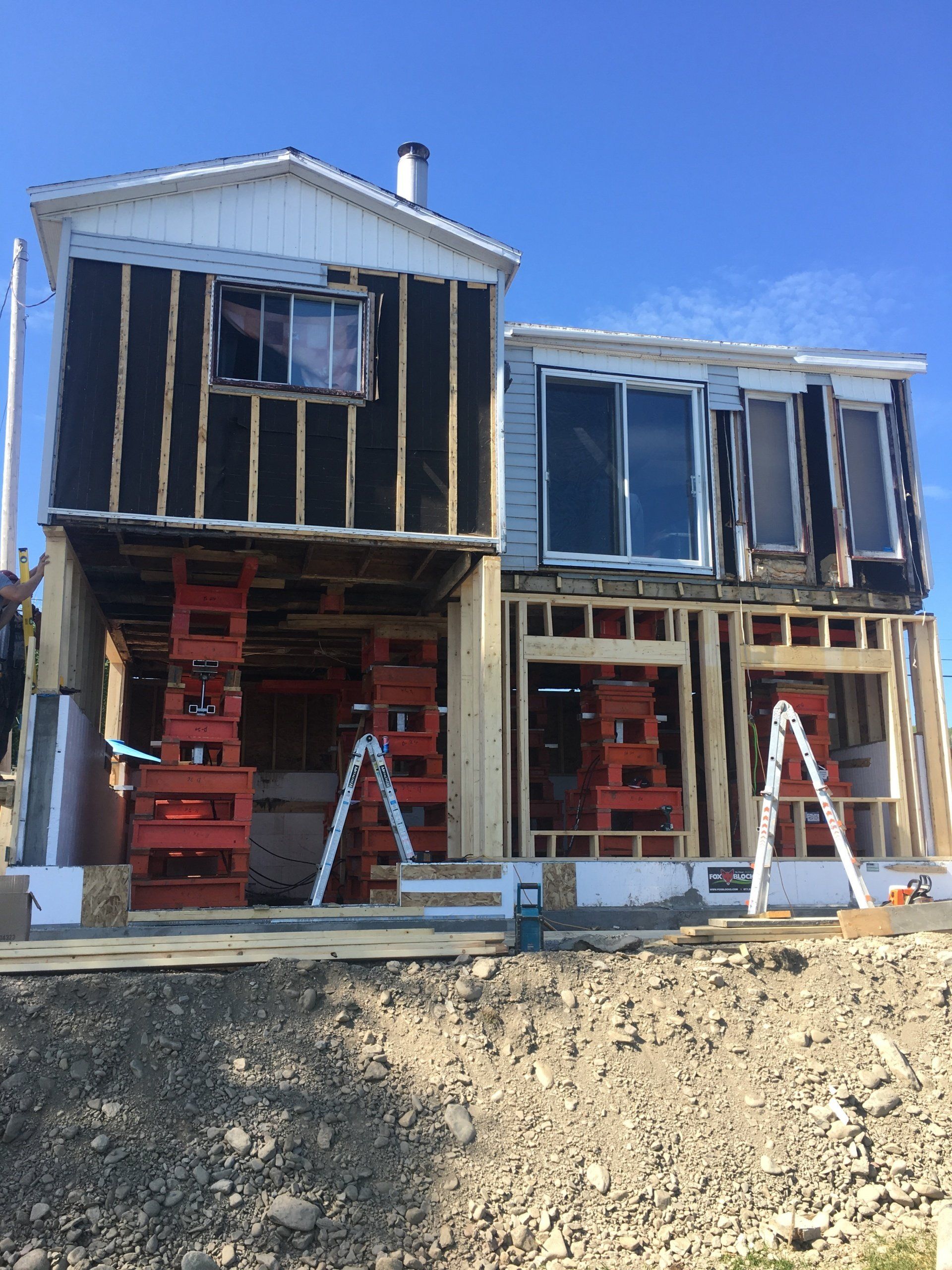 Une maison en construction avec une échelle devant elle