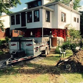 Une remorque est garée devant une maison qui est en train d'être déplacée.