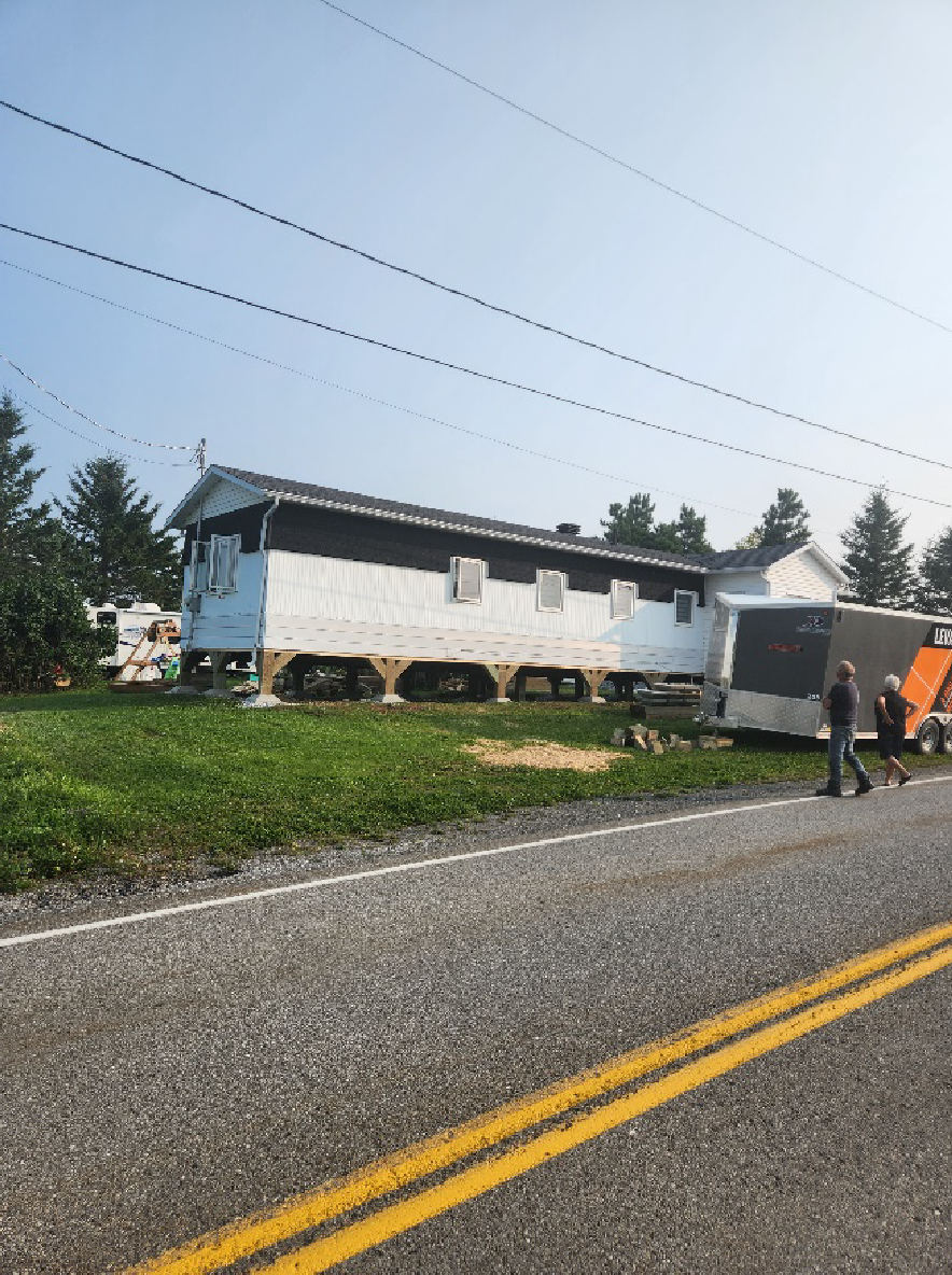 Une maison est déplacée sur la route par une remorque.