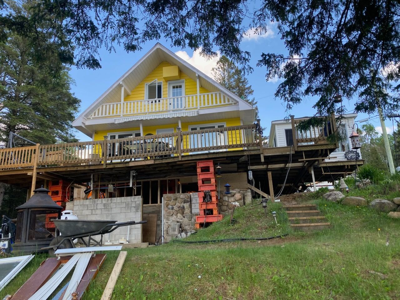 Une grande maison jaune avec une grande terrasse est en construction