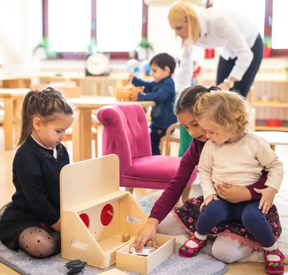 A group of children are playing with wooden toys in a classroom.