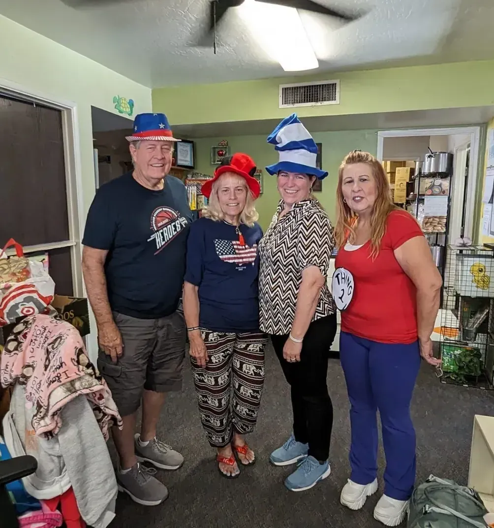 A group of people are standing in a living room wearing hats.