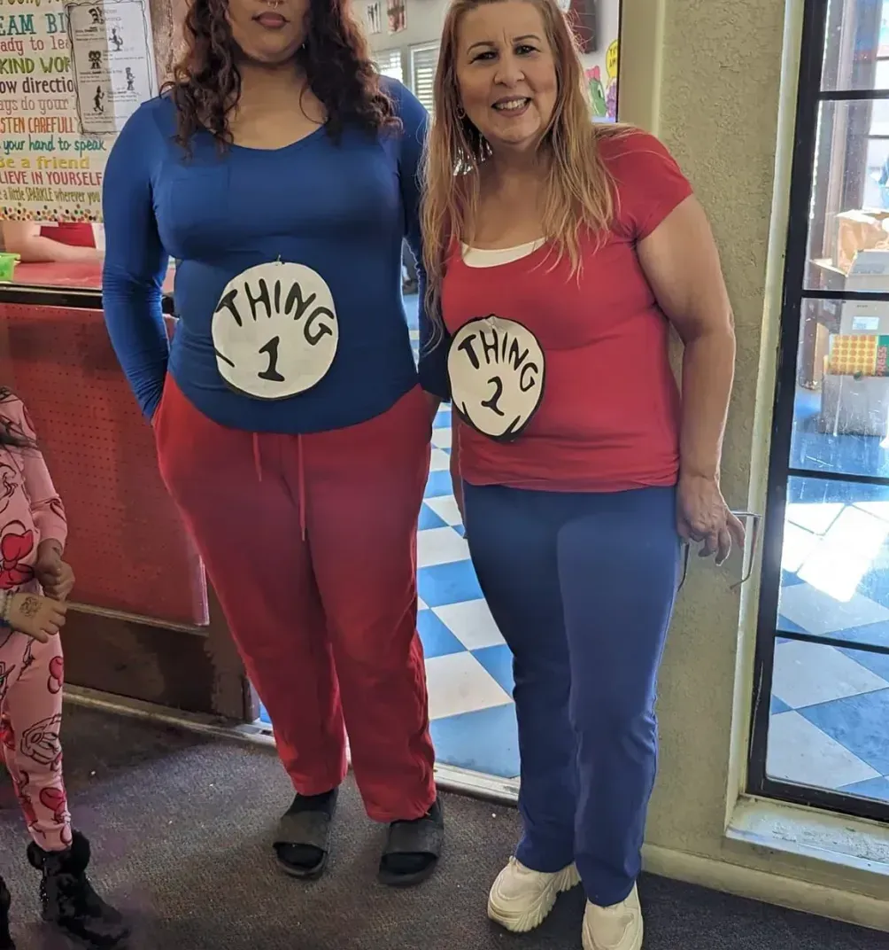 Two women in pajamas are standing next to each other in a room.