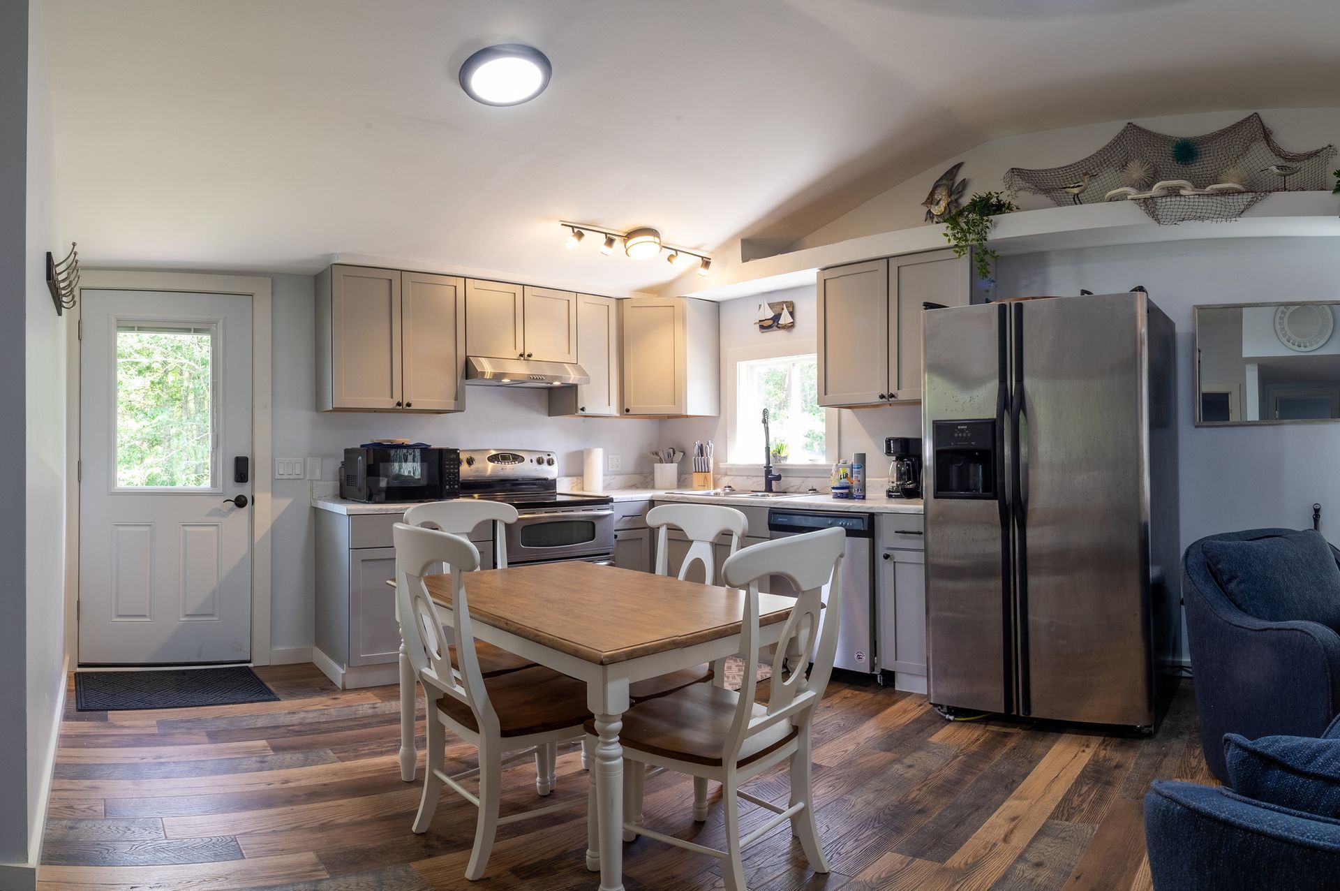 A kitchen with a table and chairs and a refrigerator.