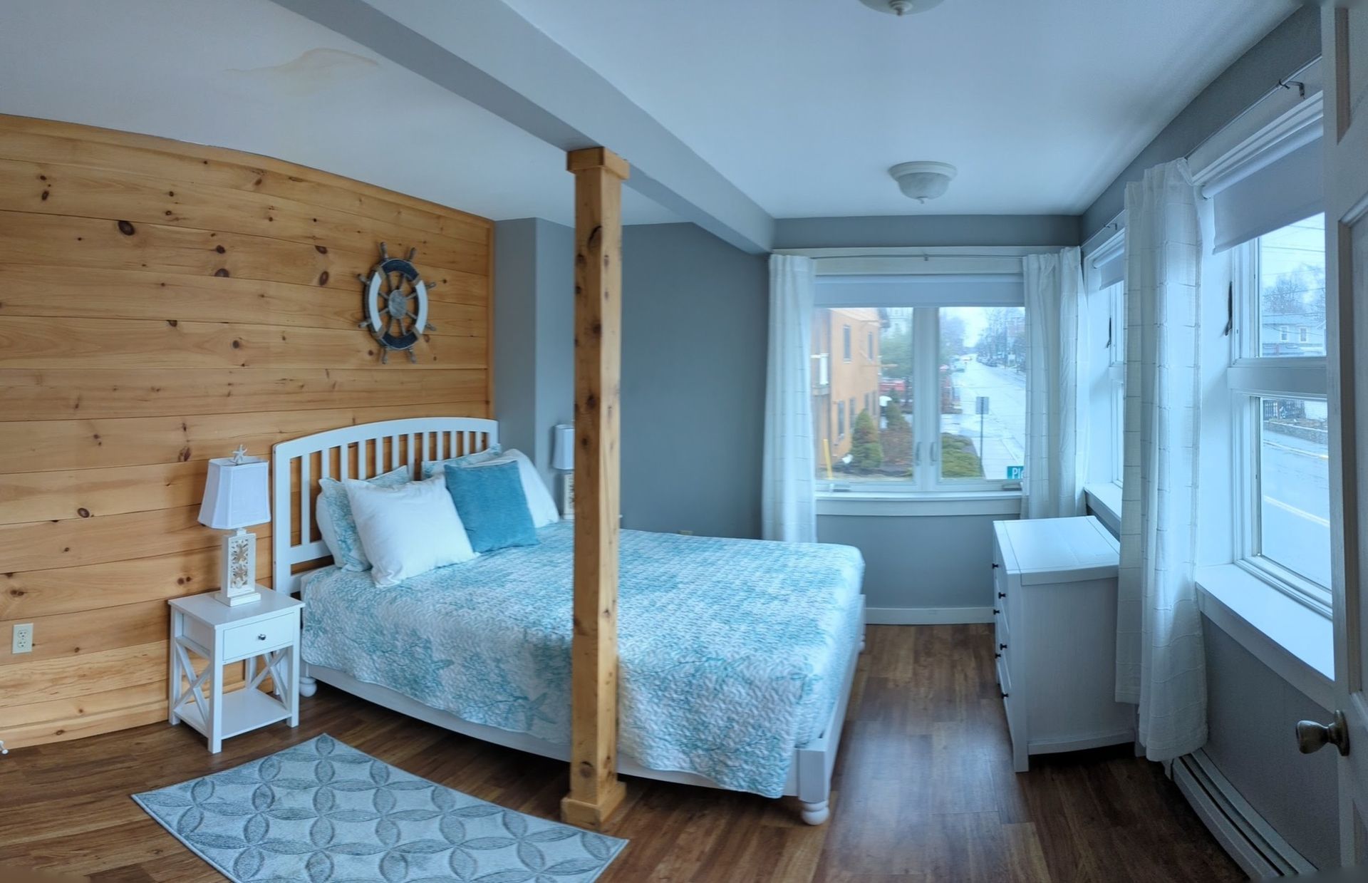 A bedroom with a bed , nightstand , and window.