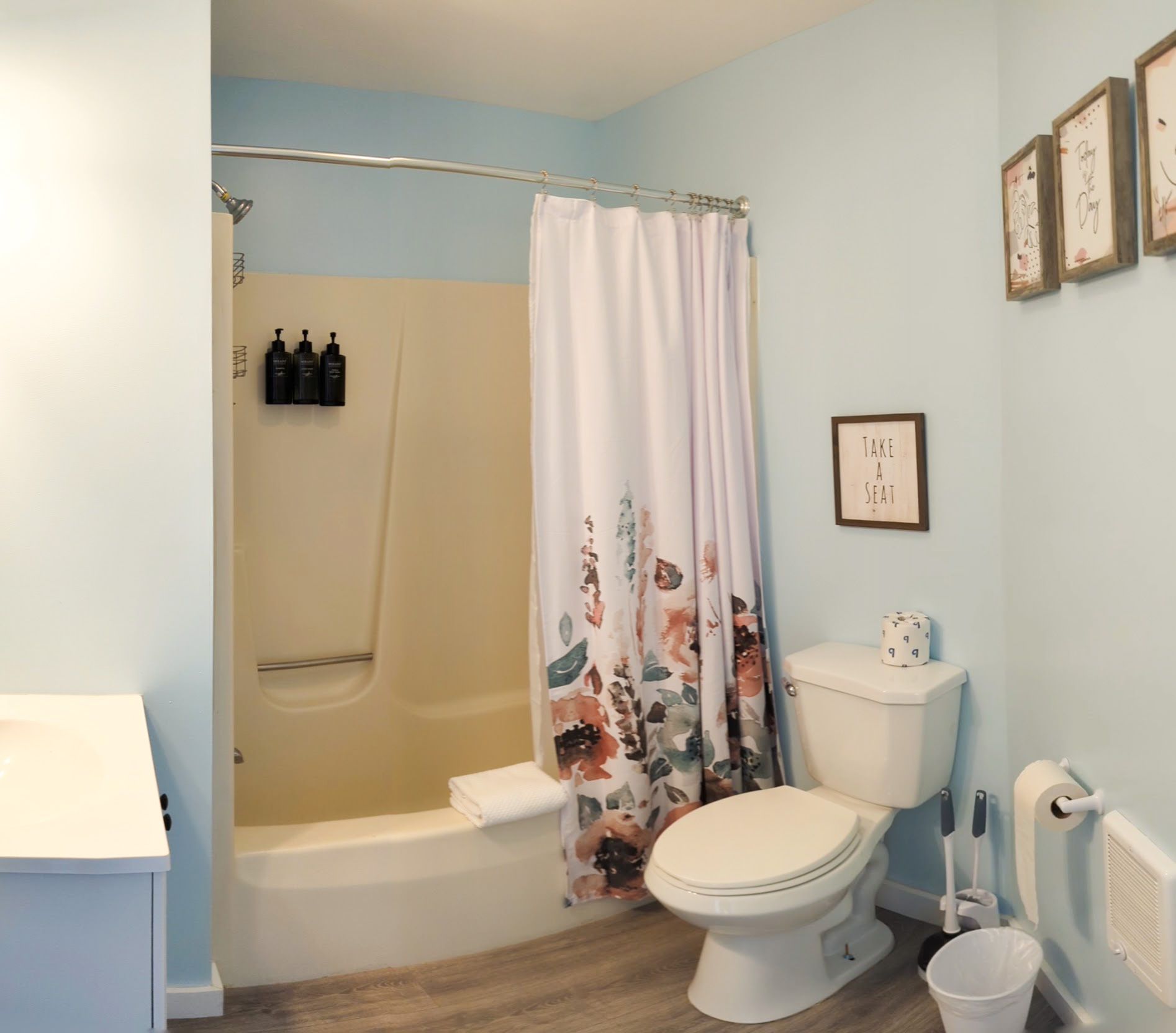 A bathroom with a toilet a bathtub and a shower curtain