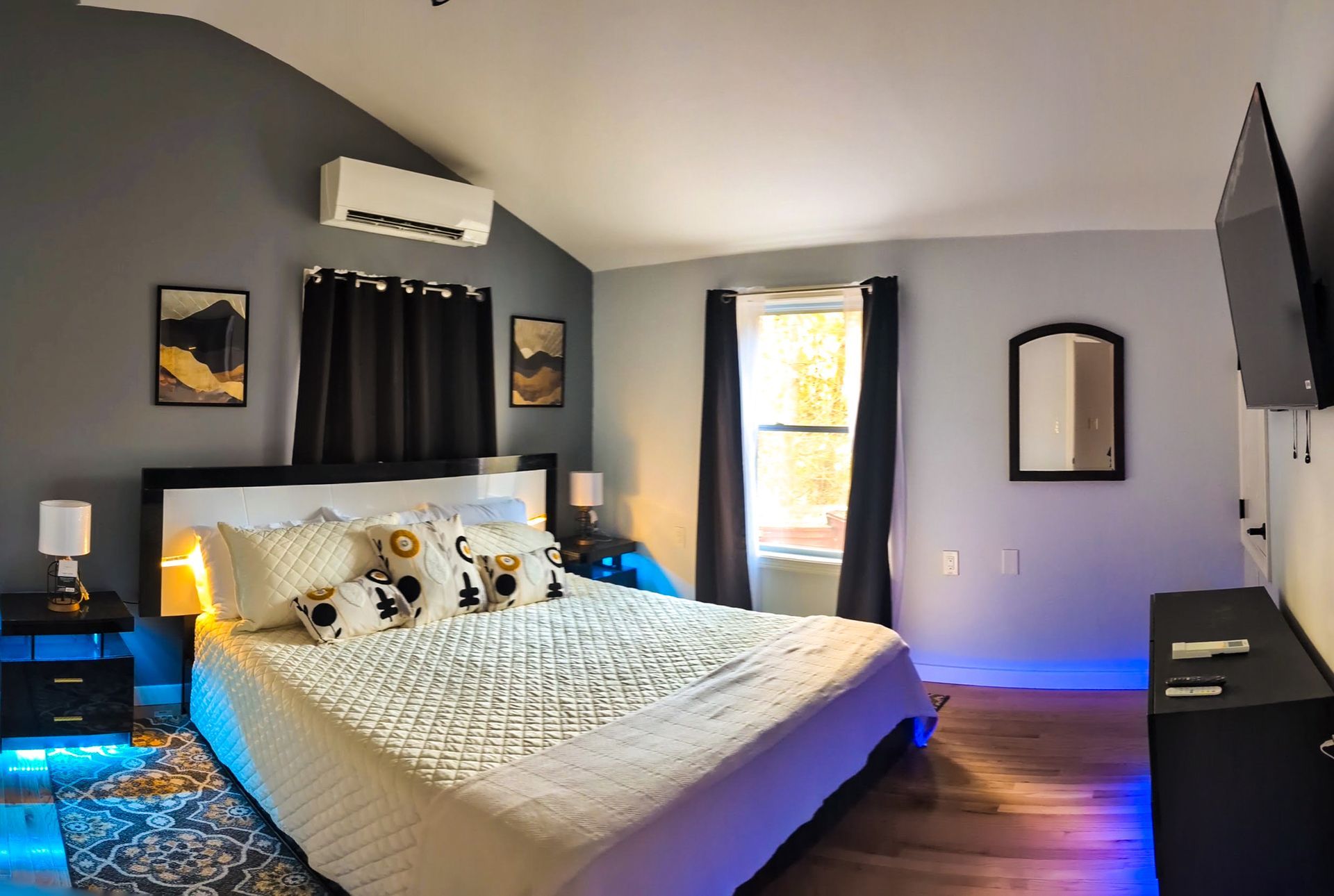 A bedroom with a king size bed and a flat screen tv.