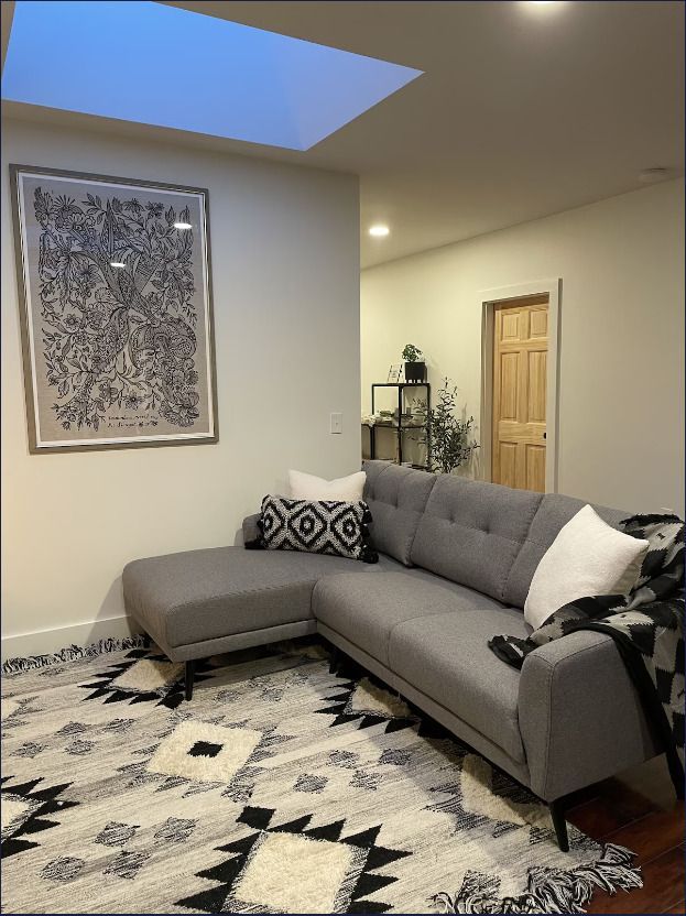 A living room with a sectional couch and a rug