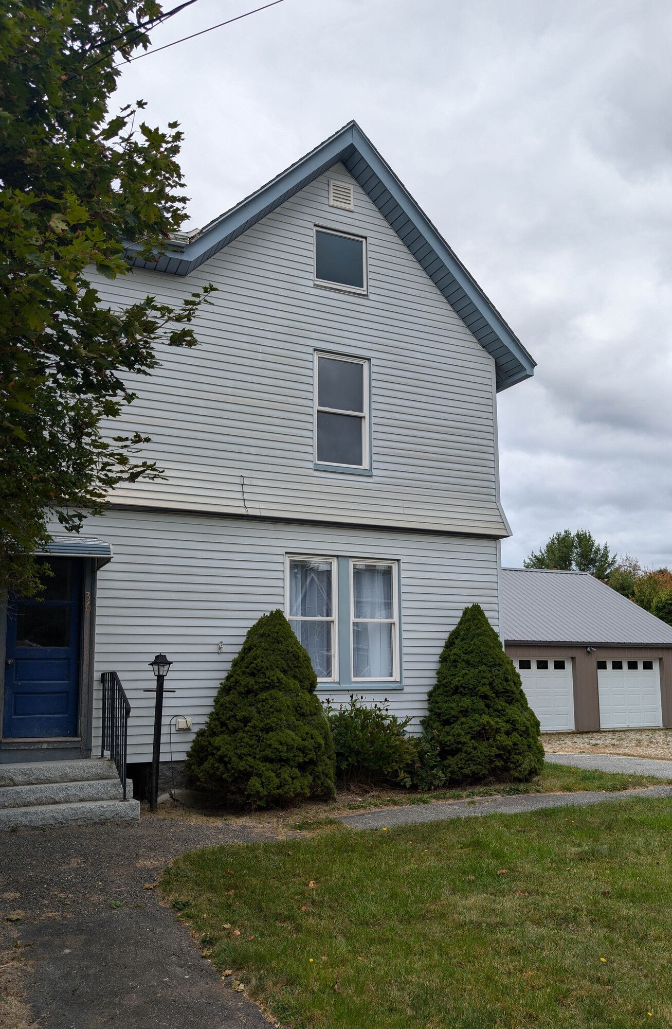 A white house with a blue door and a garage