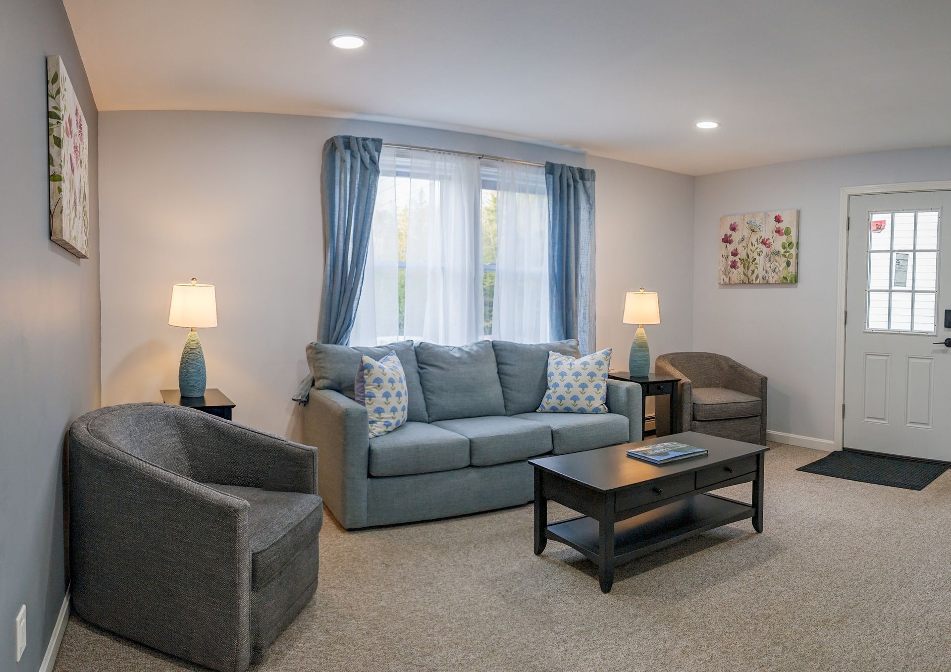 A living room with a couch , chairs , and a coffee table.