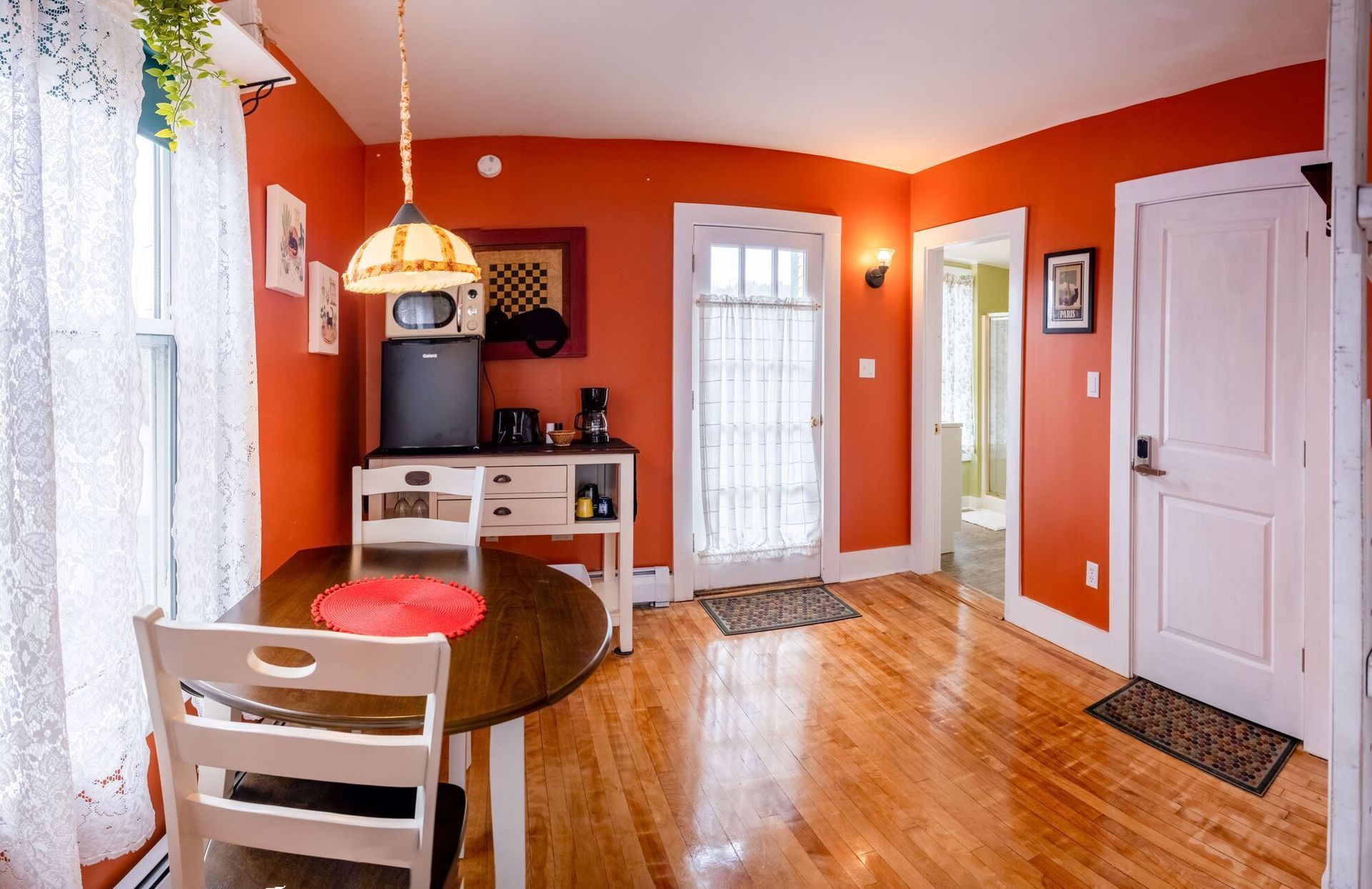 A living room with orange walls and a table and chairs