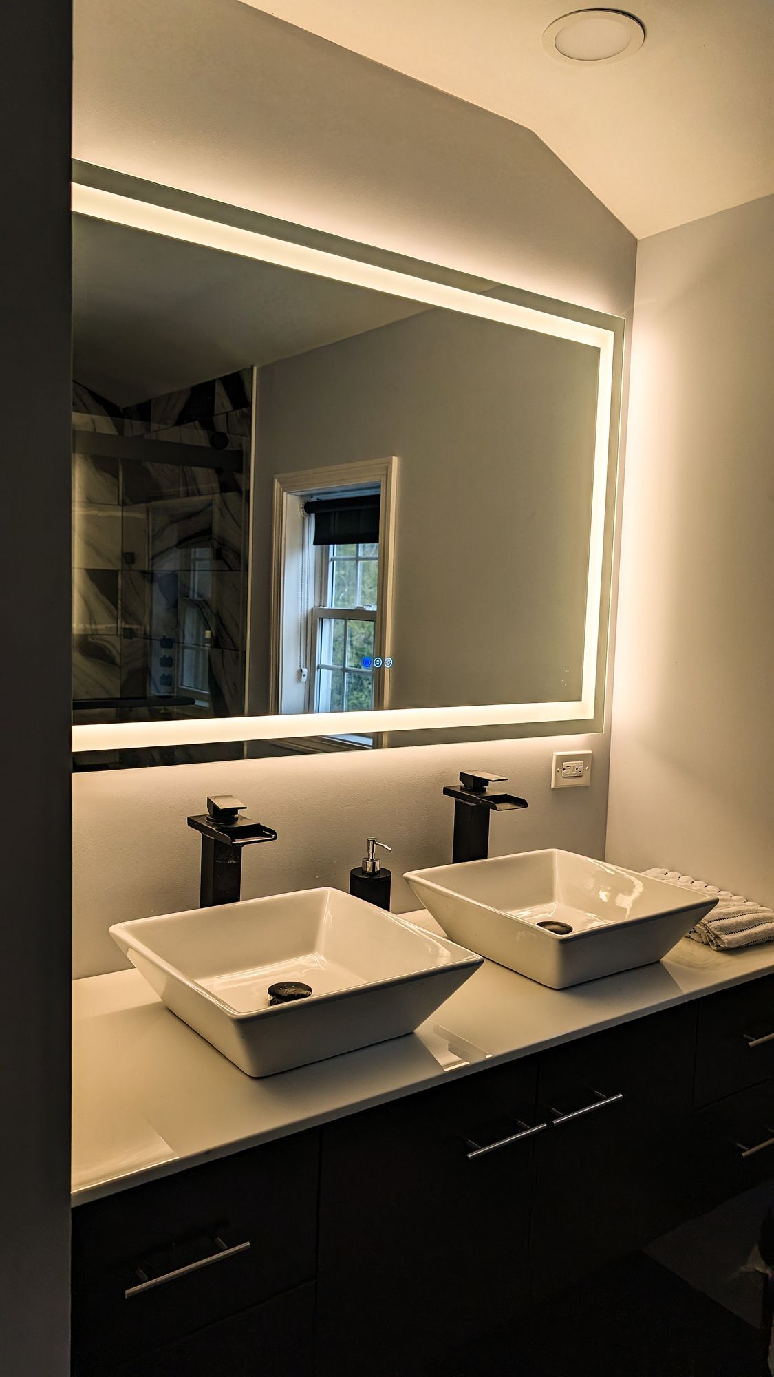 A bathroom with two sinks and a large mirror.