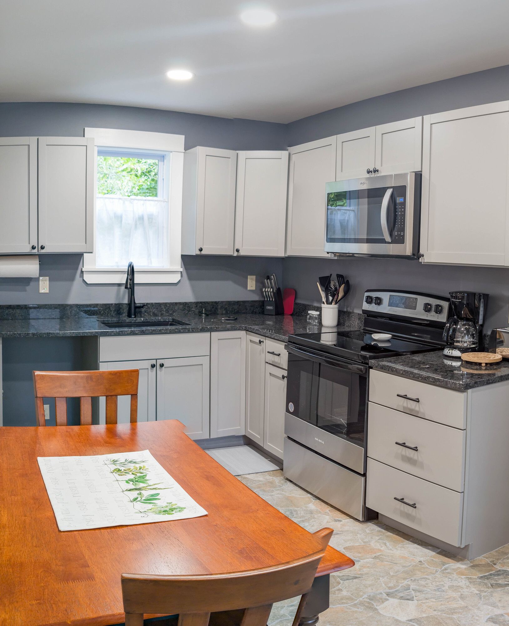A kitchen with white cabinets and stainless steel appliances