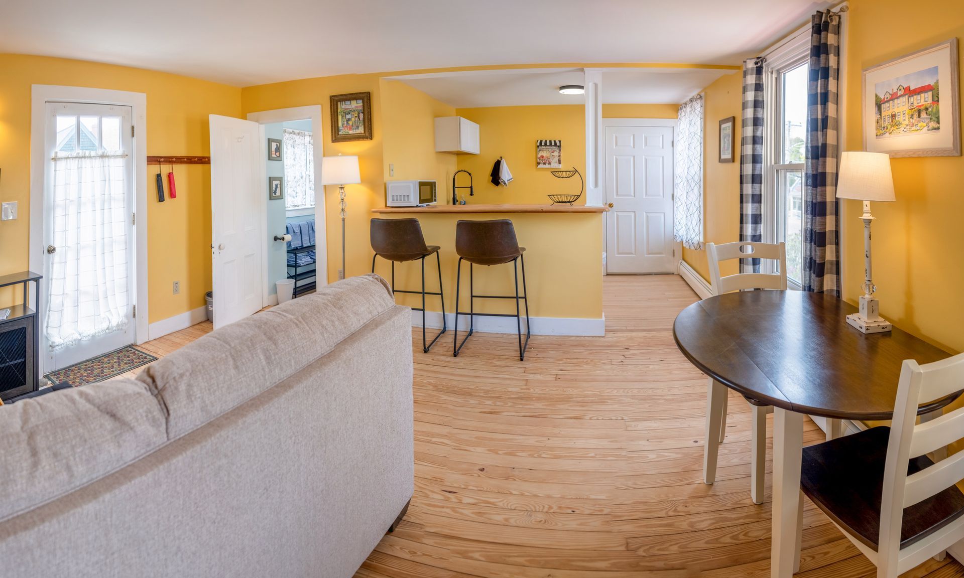 A living room with yellow walls and a table and chairs