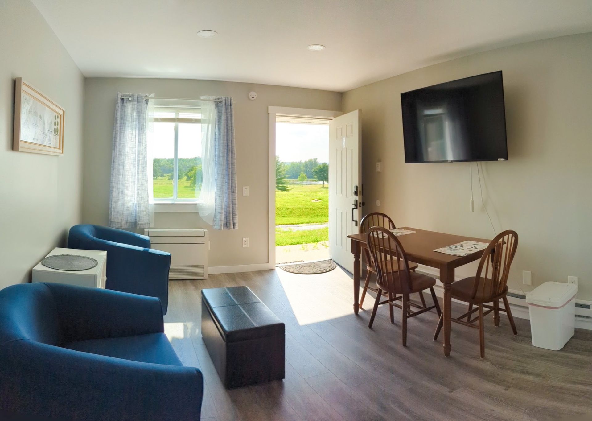 A living room with a table and chairs and a flat screen tv