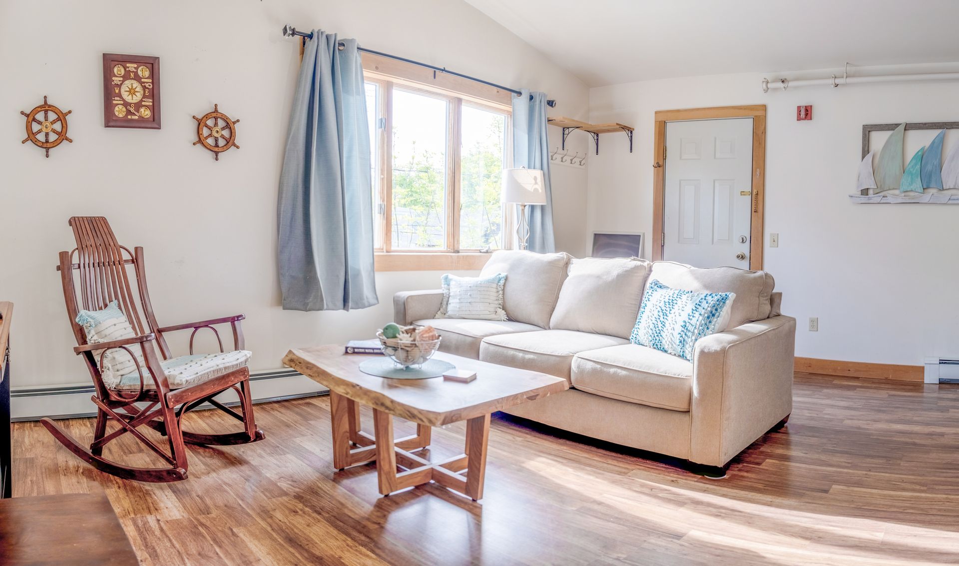 A living room with a couch , rocking chair , and coffee table.