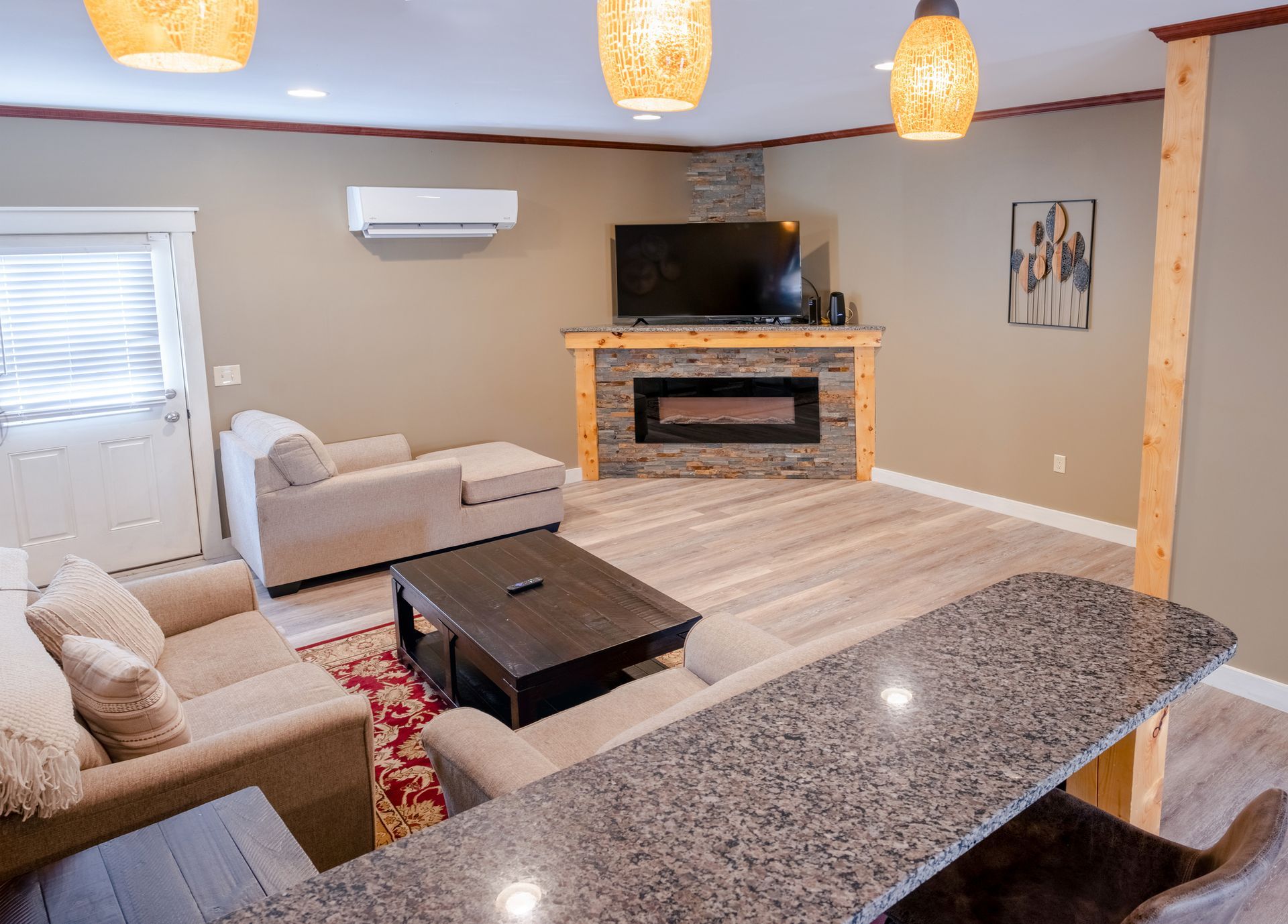 A living room with a couch , chair , coffee table and television.