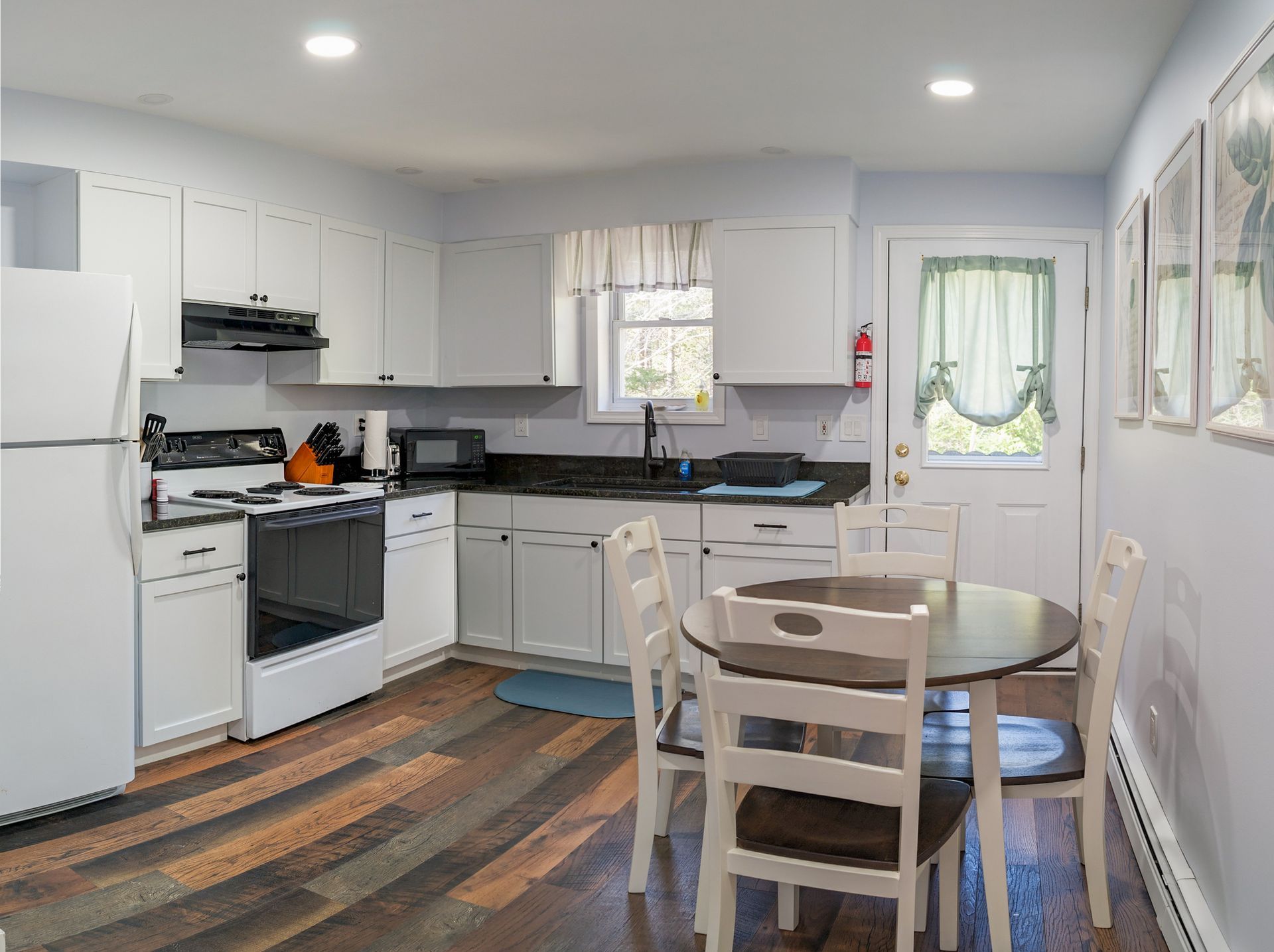 A kitchen with a table and chairs and a refrigerator.