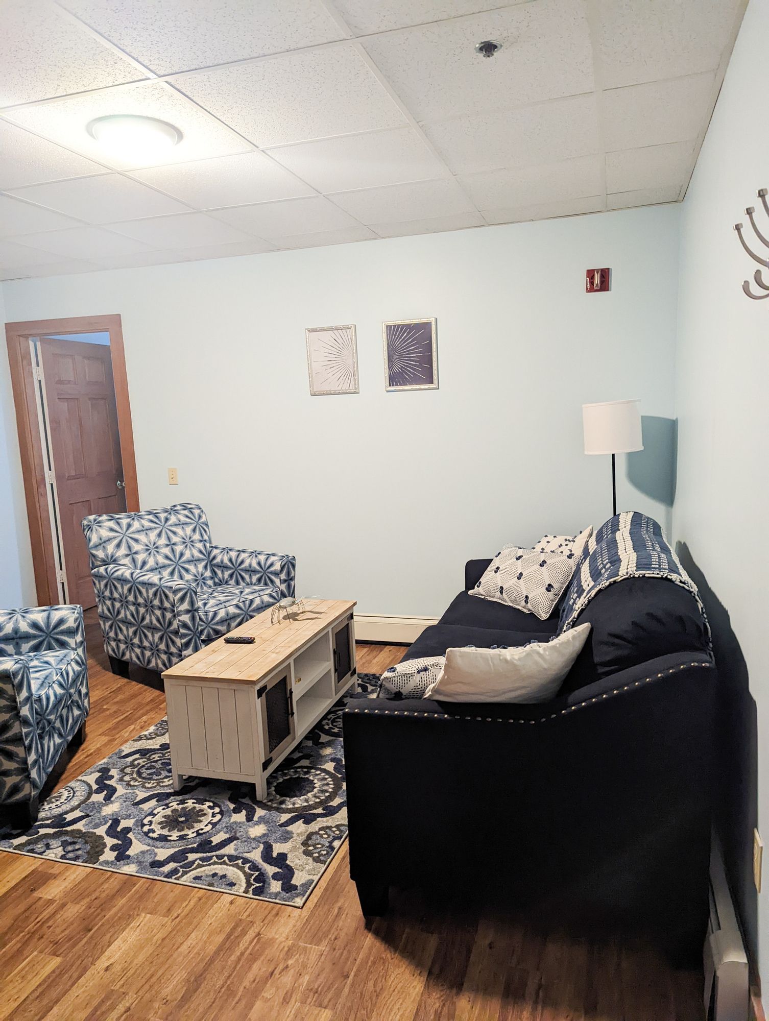 A living room with a couch , chairs , and a coffee table.