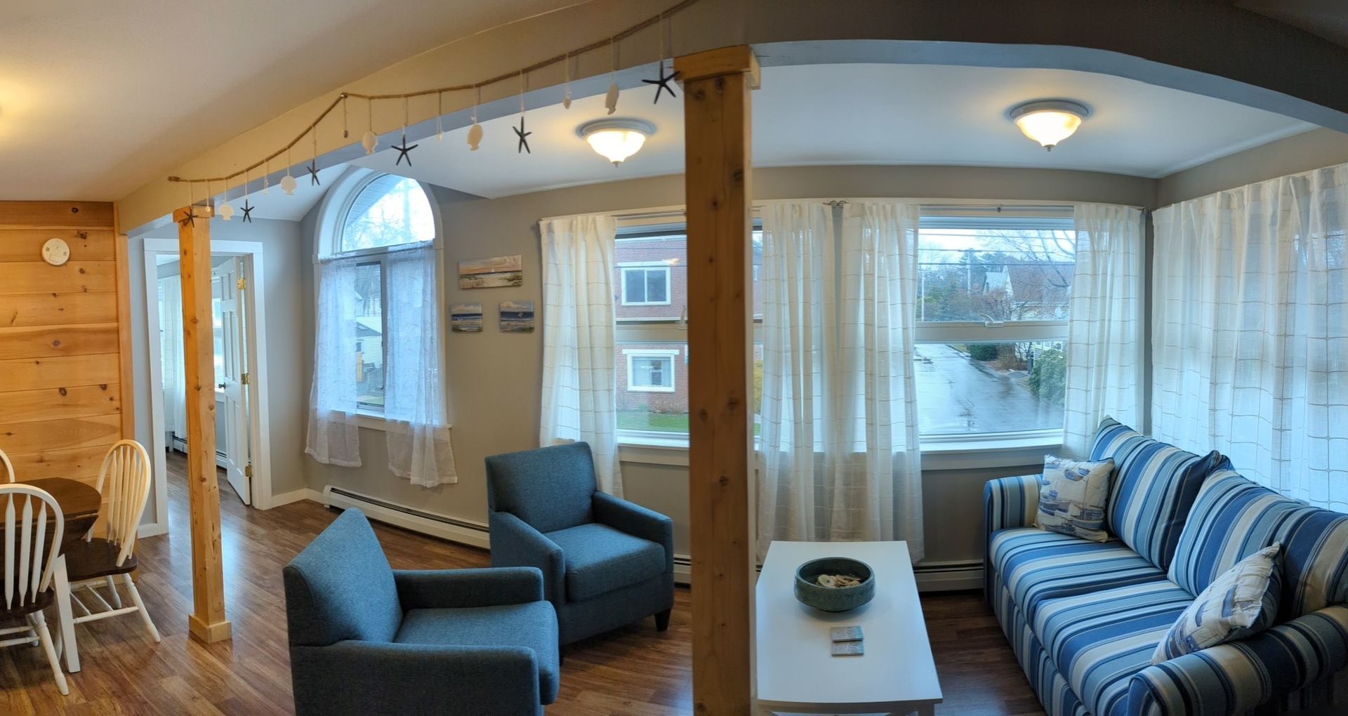 A living room with a couch , chairs , and a table.