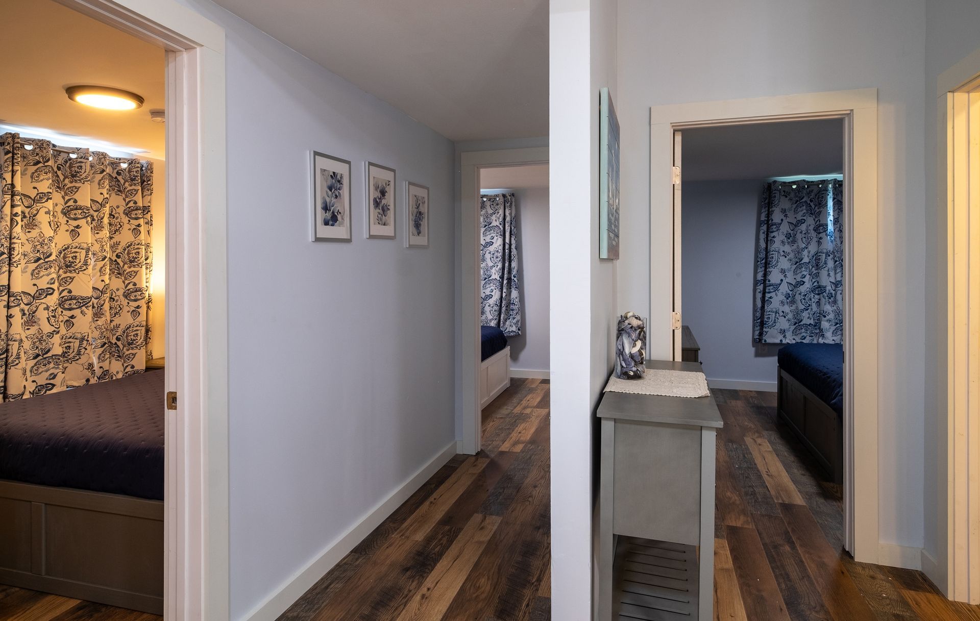 A hallway in a house leading to a bedroom and a bathroom.