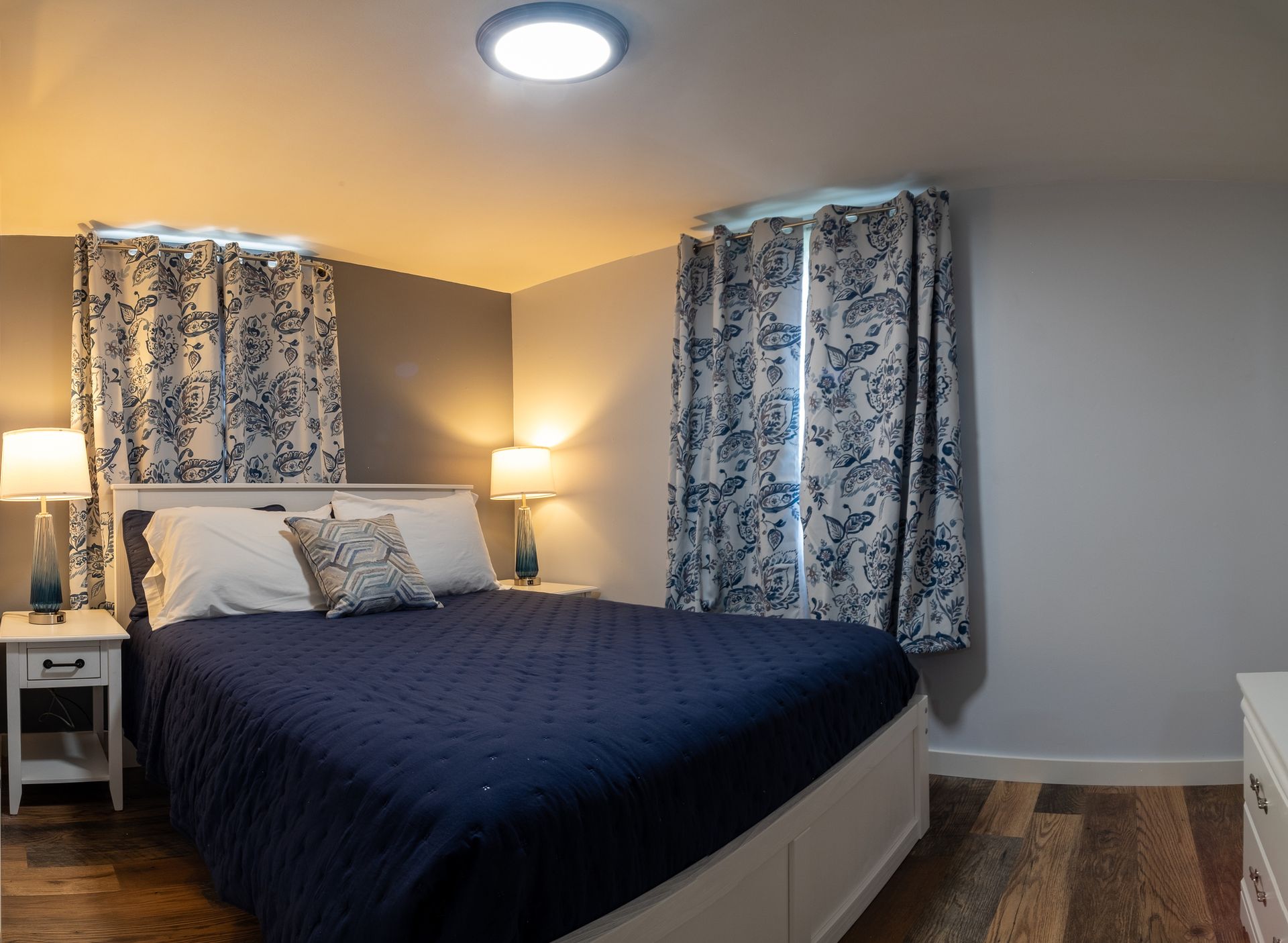 A bedroom with a king size bed and floral curtains