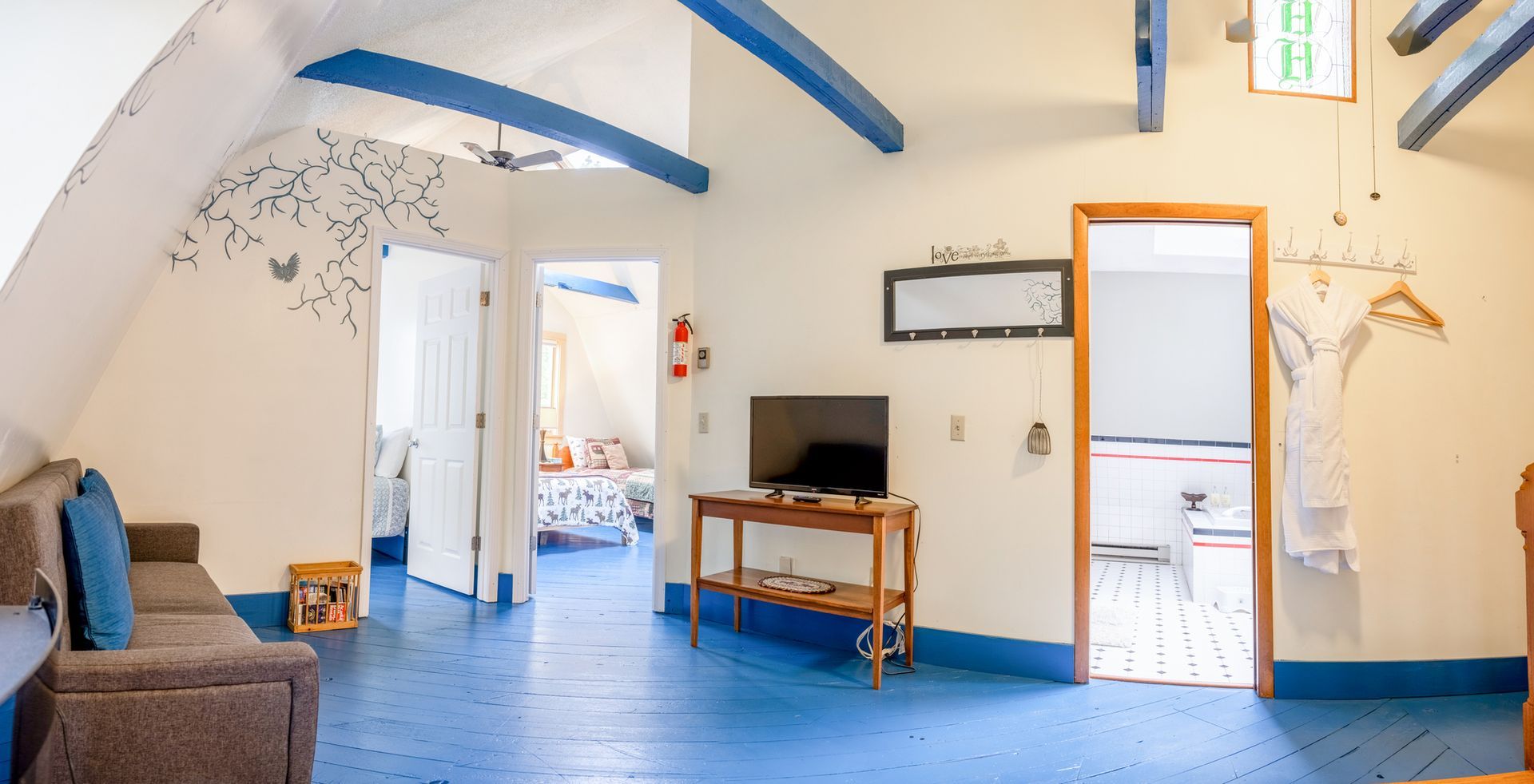 A living room with a couch , television , and blue floors.