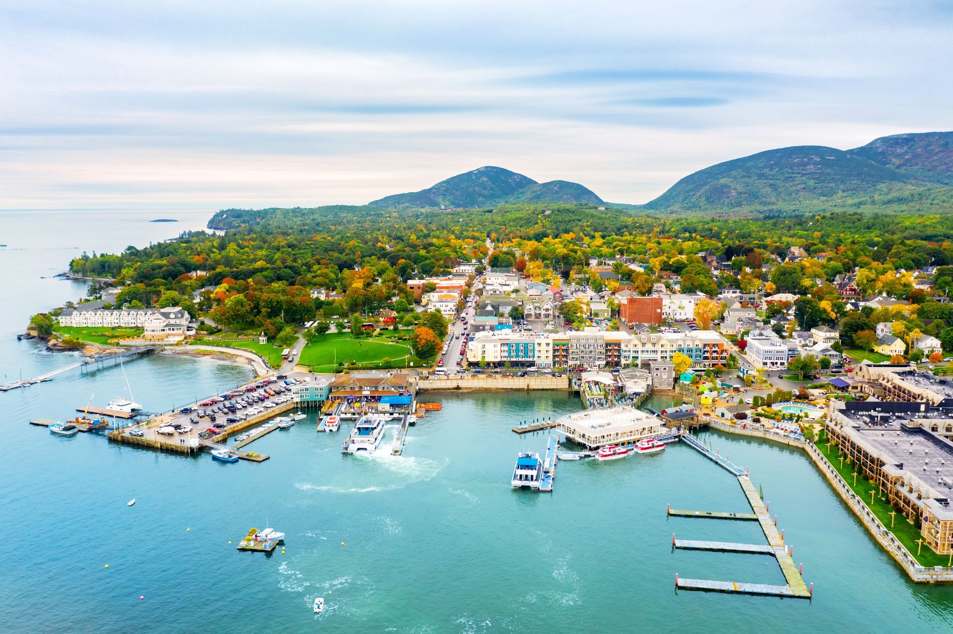 An aerial view of a small town surrounded by water and mountains.
