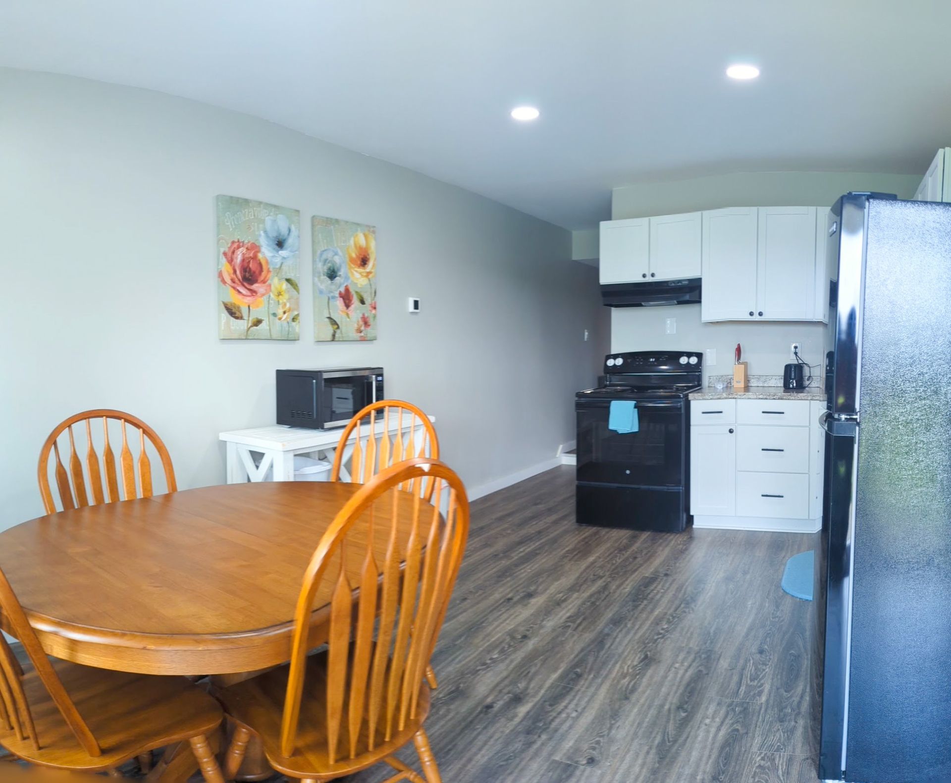 A kitchen with a table and chairs and a refrigerator