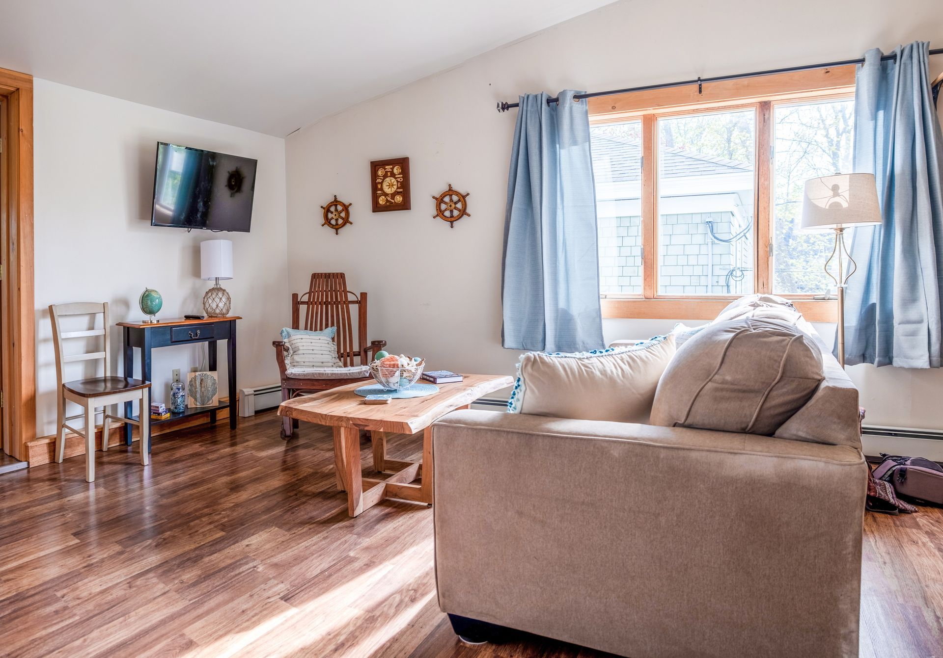 A living room with a couch , chair , table and television.