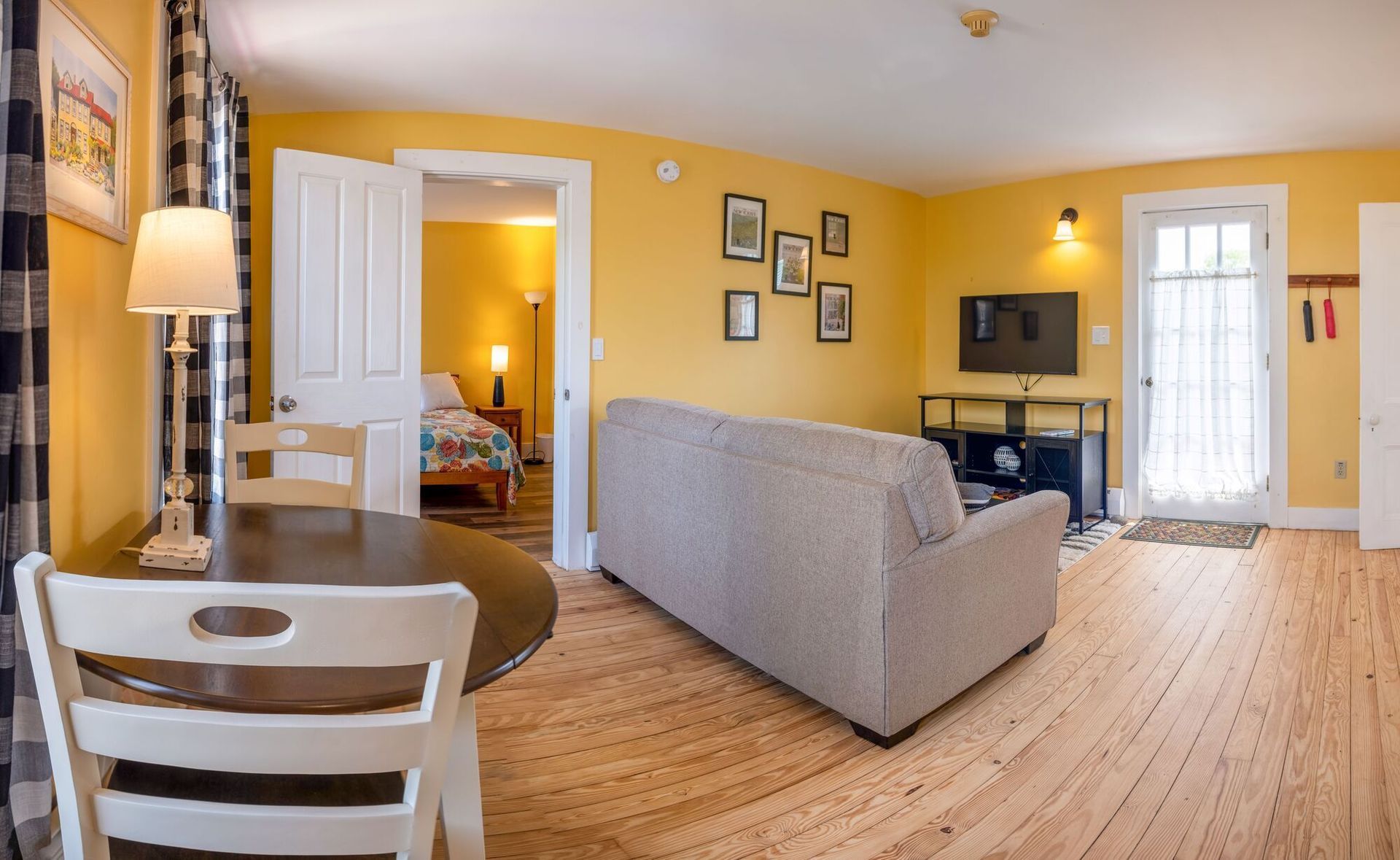 A living room with a couch , table , chairs and a television.