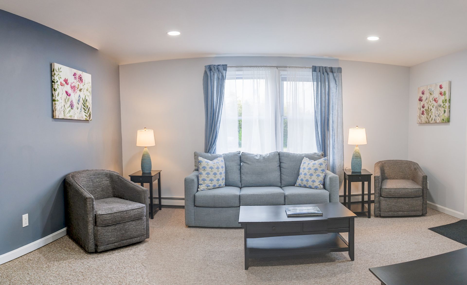 A gravel road leading to a motel with umbrellas and picnic tables