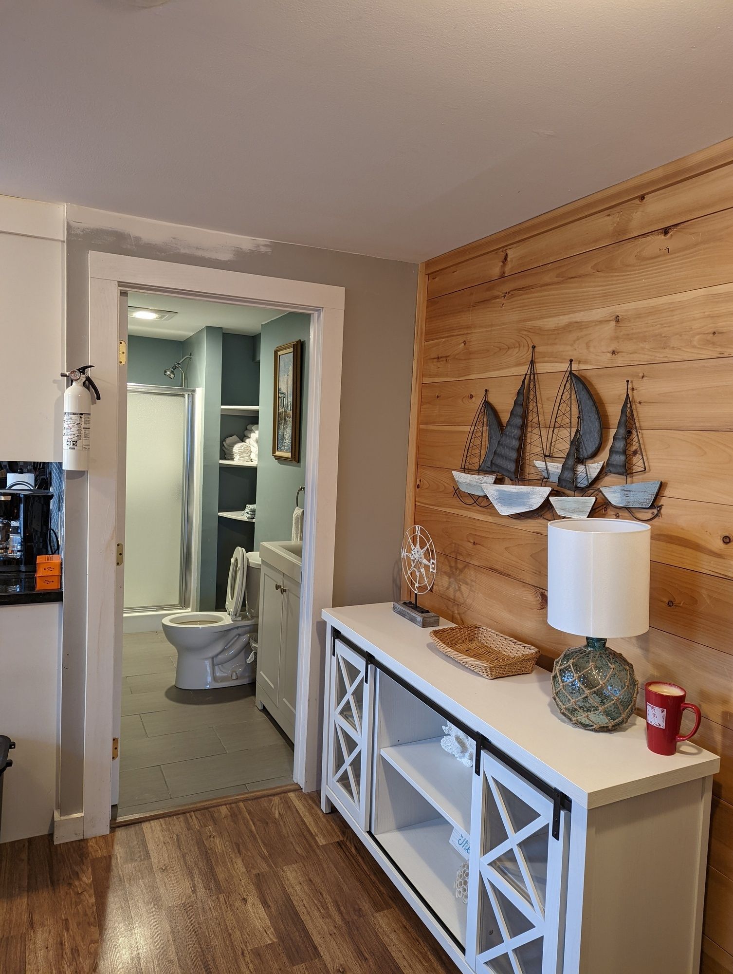 A living room with a wooden wall and a white cabinet.