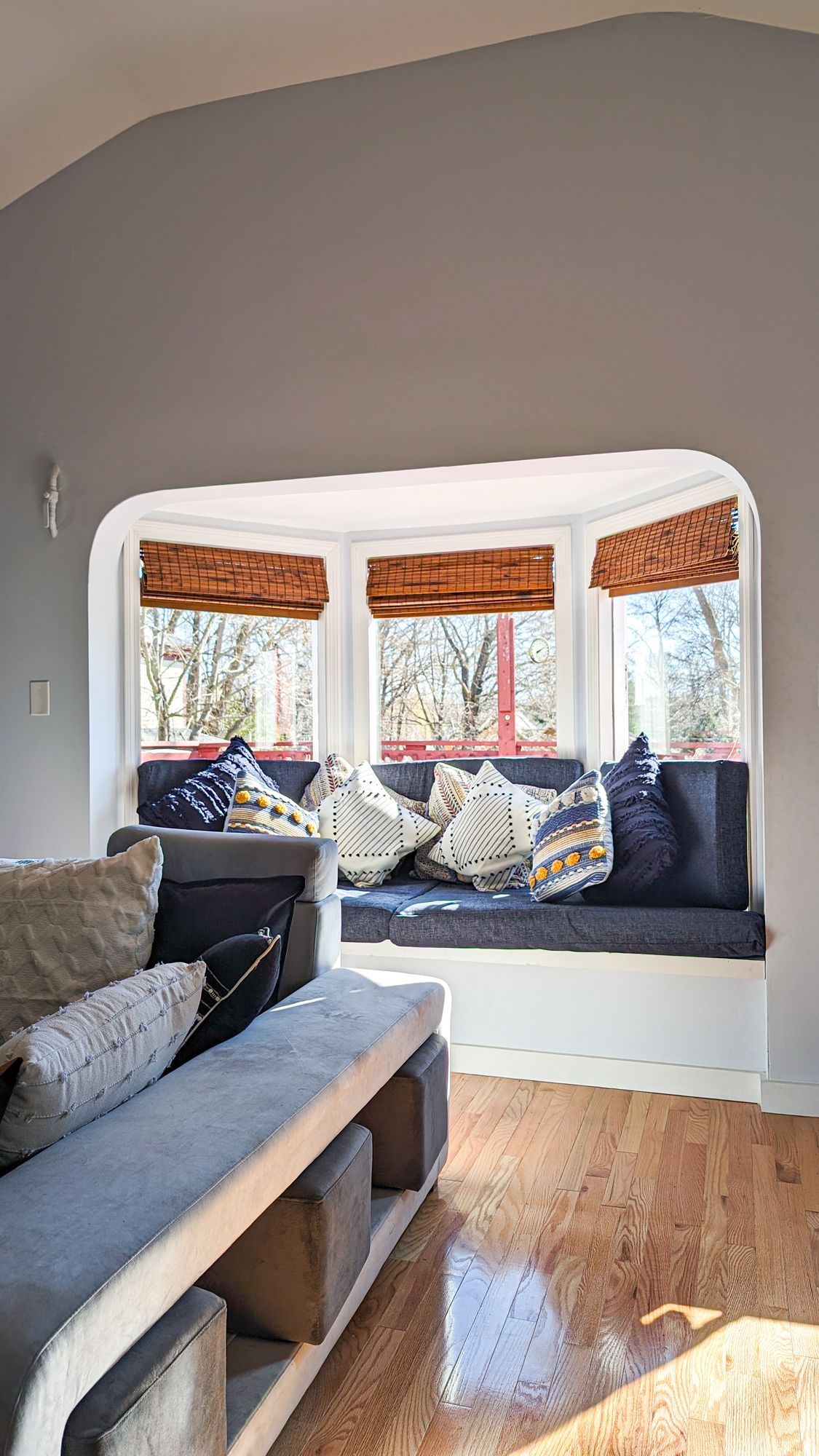 A living room with a bay window and a couch.