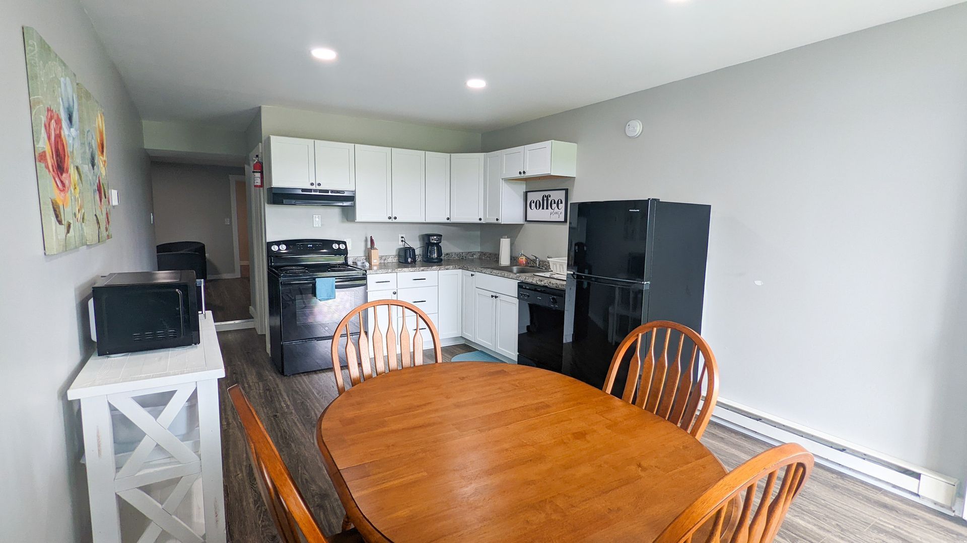 A kitchen with a table and chairs and a refrigerator.