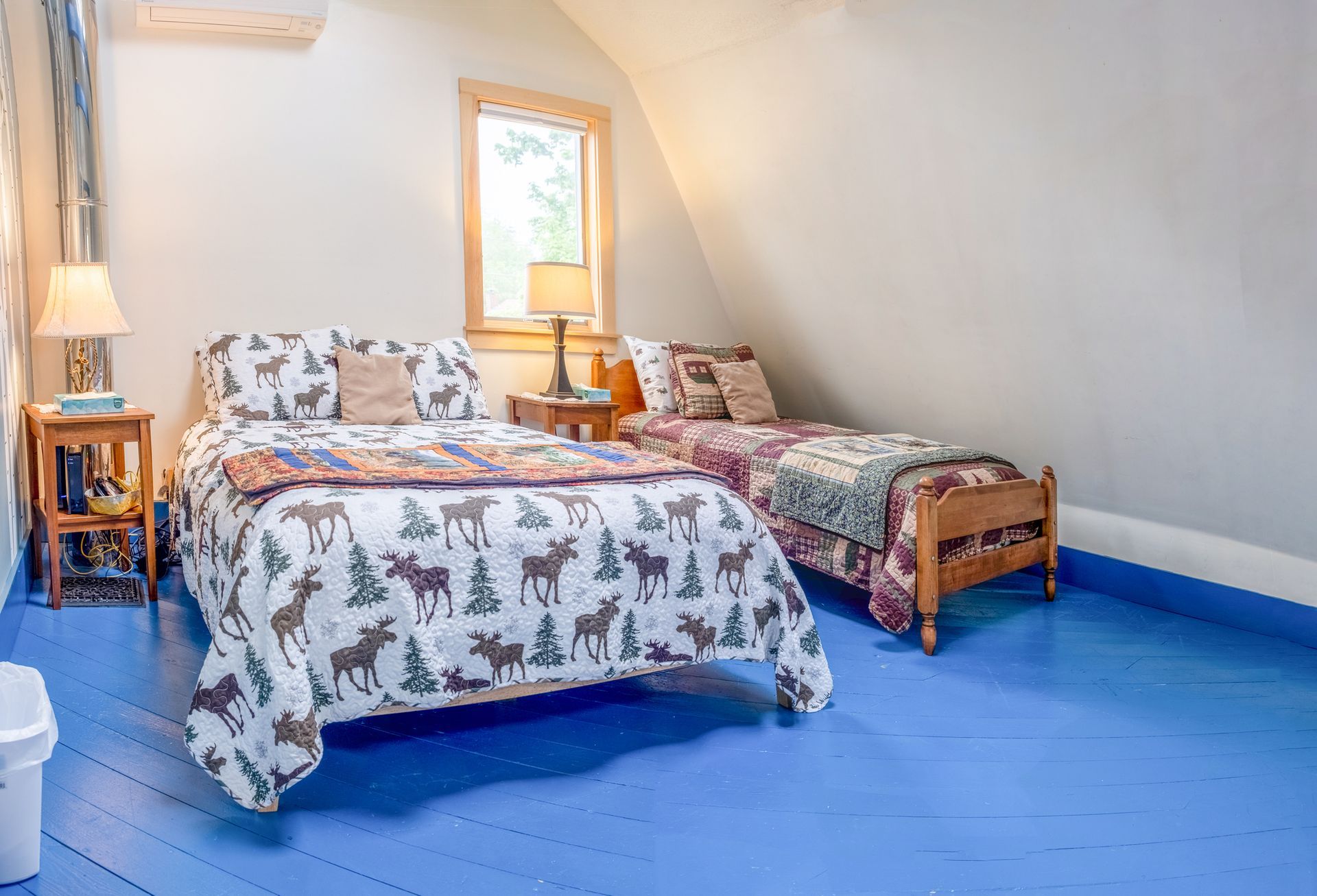 A bedroom with two beds and a blue floor.