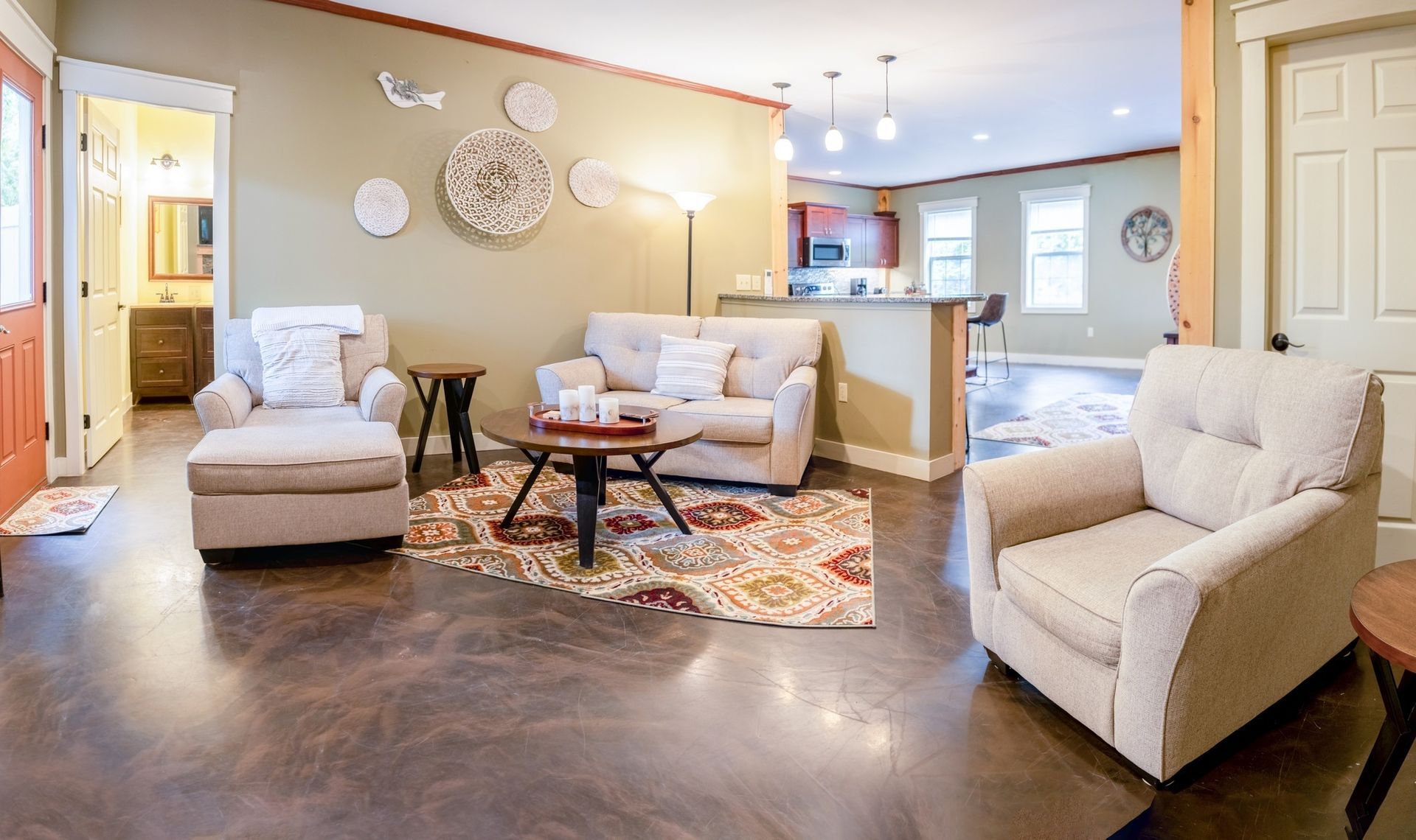 A living room with a couch , chairs , and a coffee table.