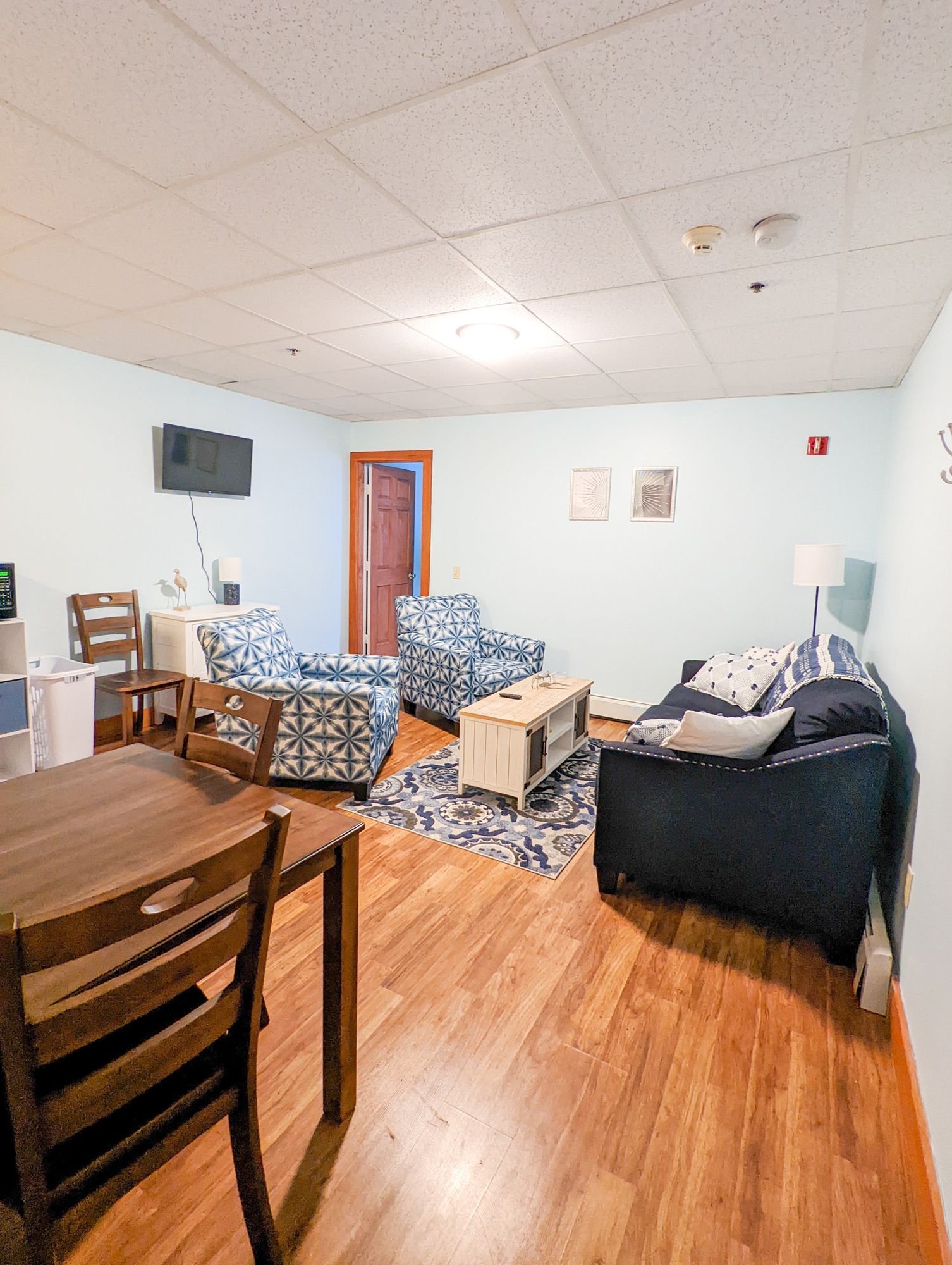 A living room with a couch , chairs , table and television.