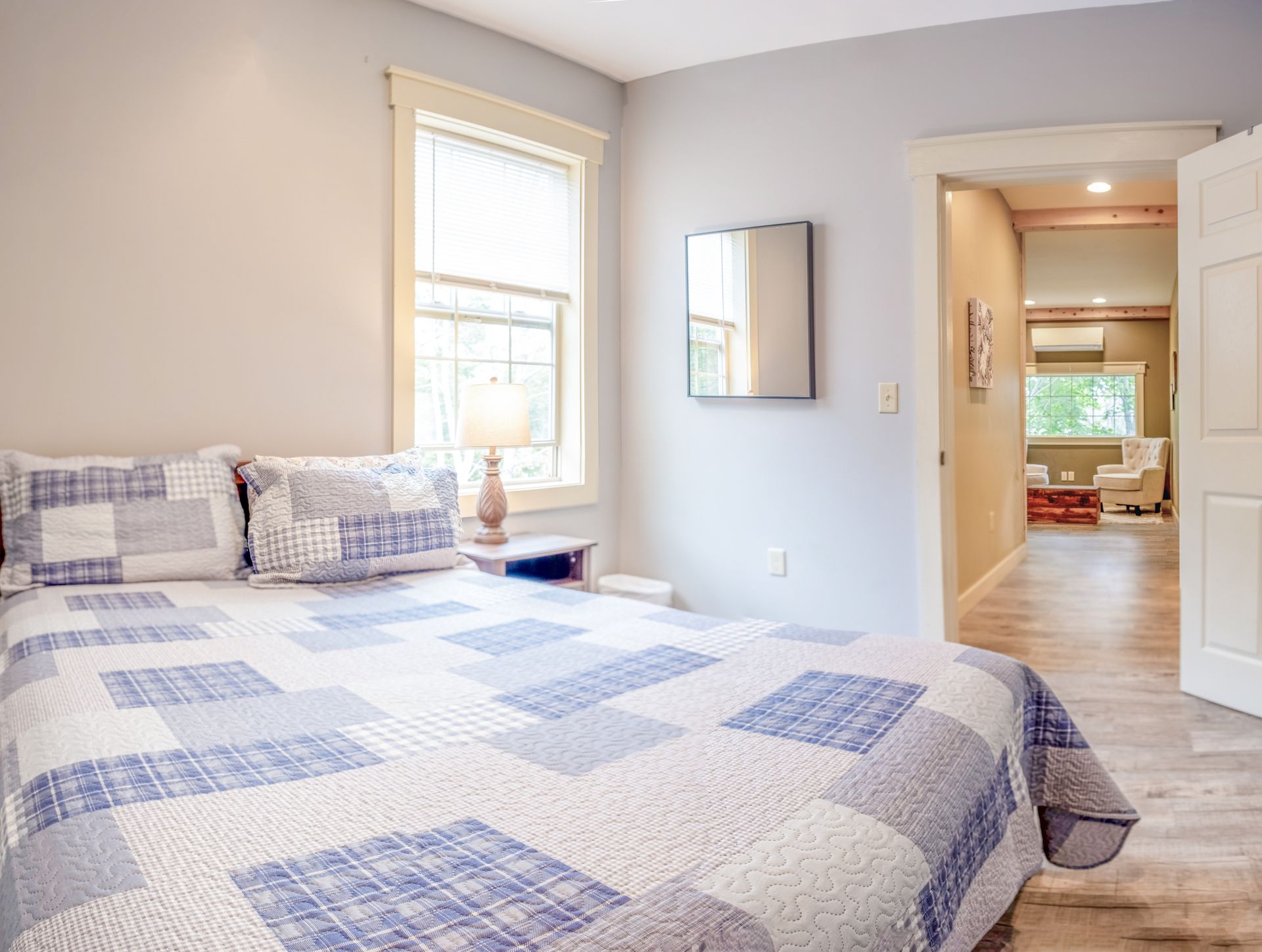 A bedroom with a king size bed and a mirror on the wall.