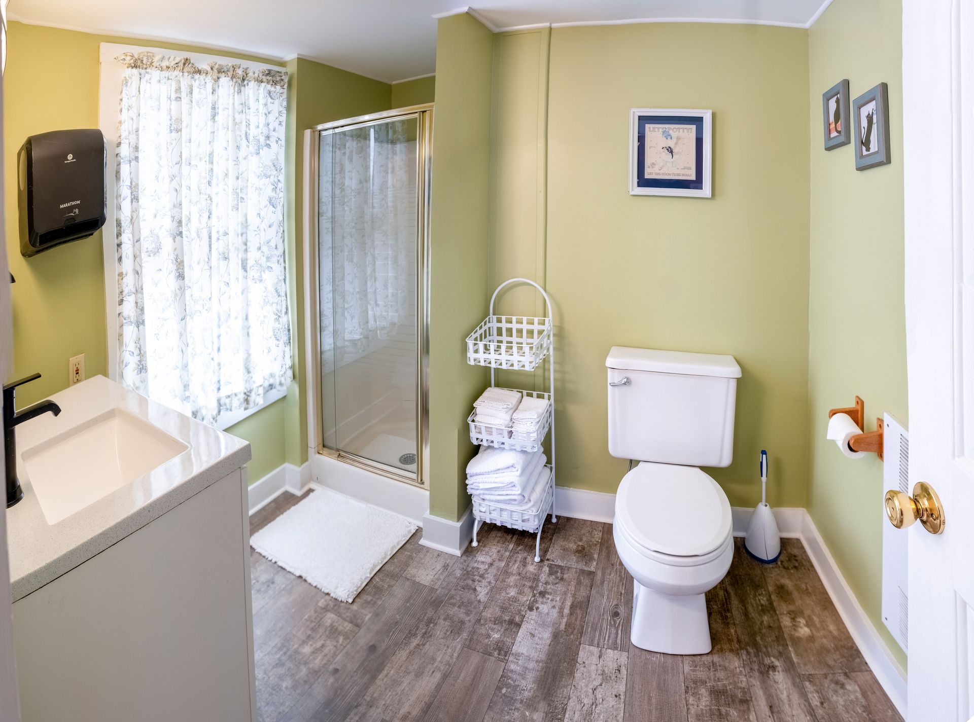 A bathroom with a toilet , sink and shower.
