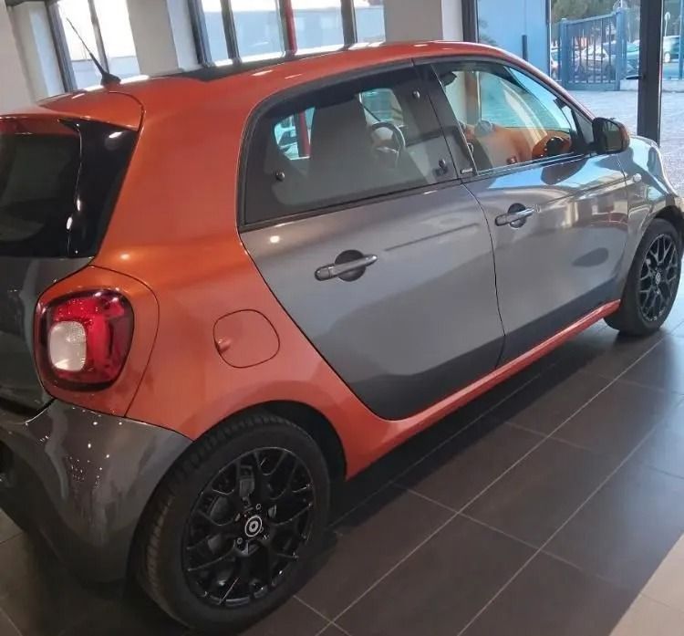 Un'auto grigia e arancione è parcheggiata in uno showroom