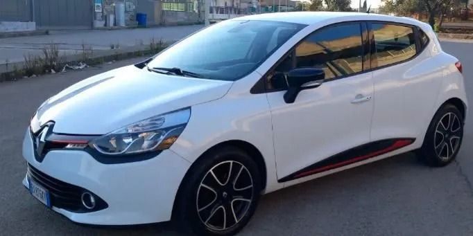 Un'auto bianca è parcheggiata sul ciglio della strada.