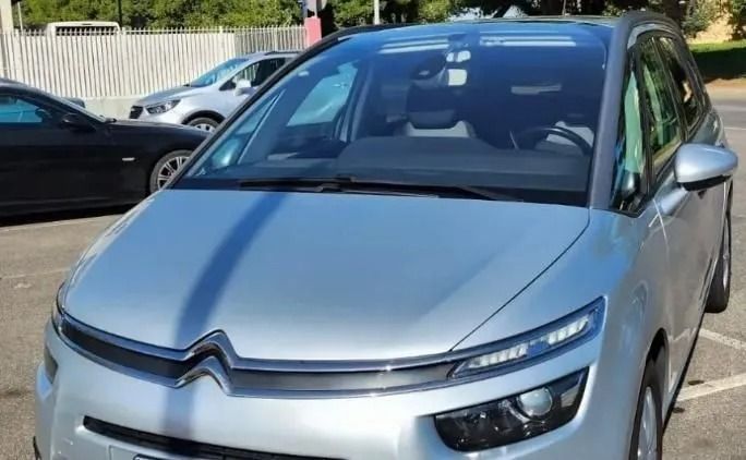 Un'auto argentata è parcheggiata in un parcheggio accanto a un'auto nera.