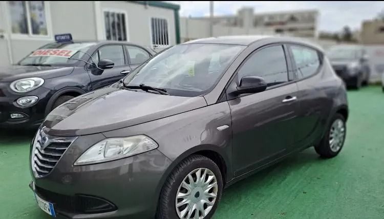 Un'auto grigia è parcheggiata accanto a un'auto nera in un parcheggio.