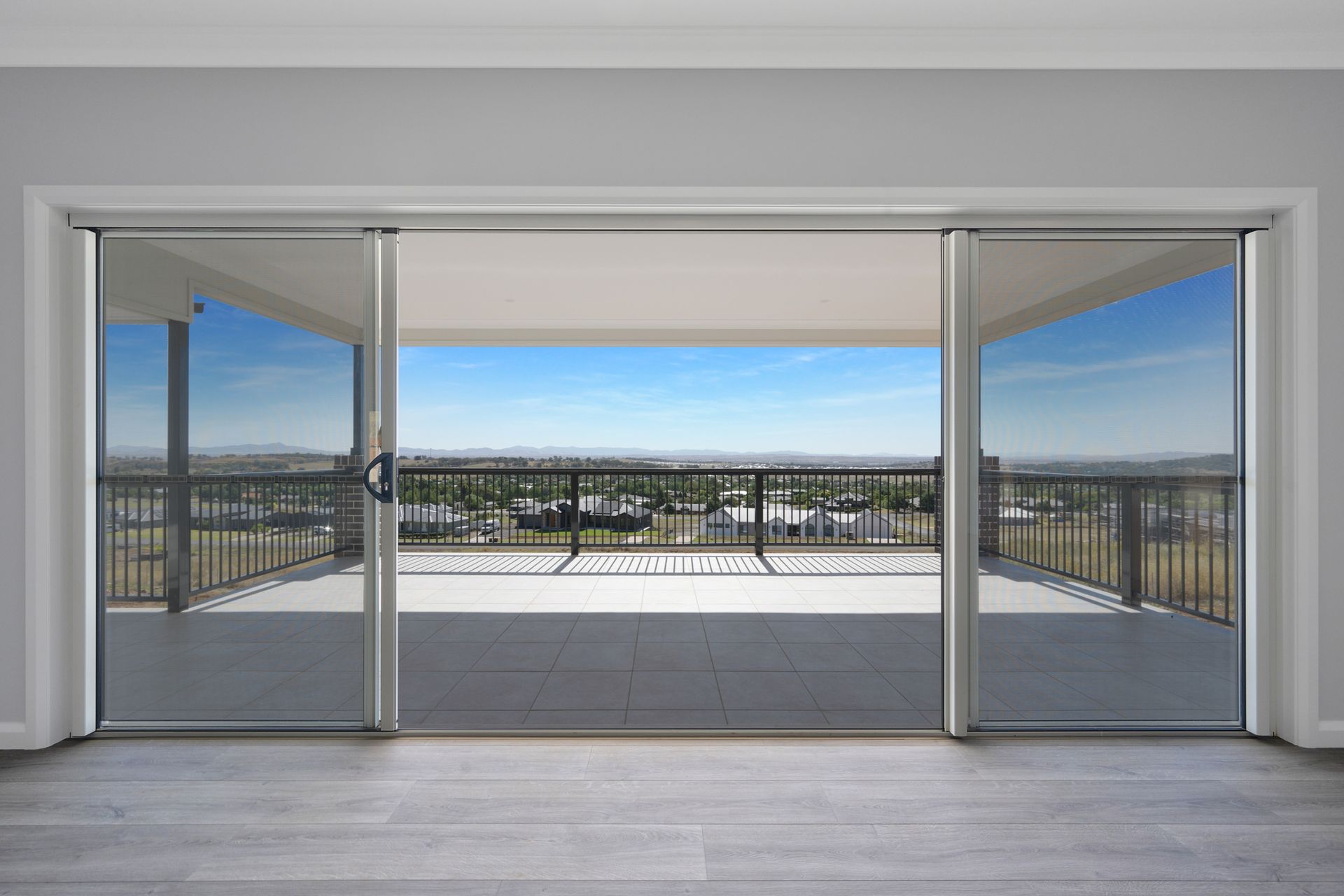 An empty room with sliding glass doors leading to a balcony.