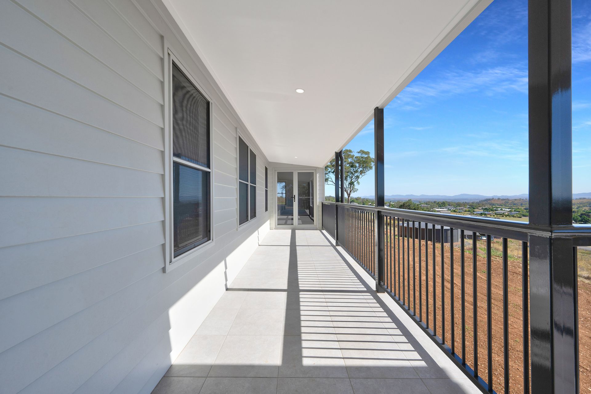 A long white porch with a black railing